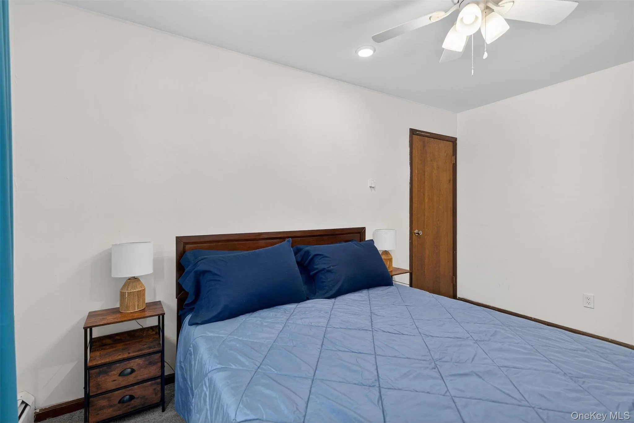Carpeted bedroom with ceiling fan, recessed lighting, and baseboard heating Carpeted bedroom with ceiling fan, recessed lighting, and baseboard heating