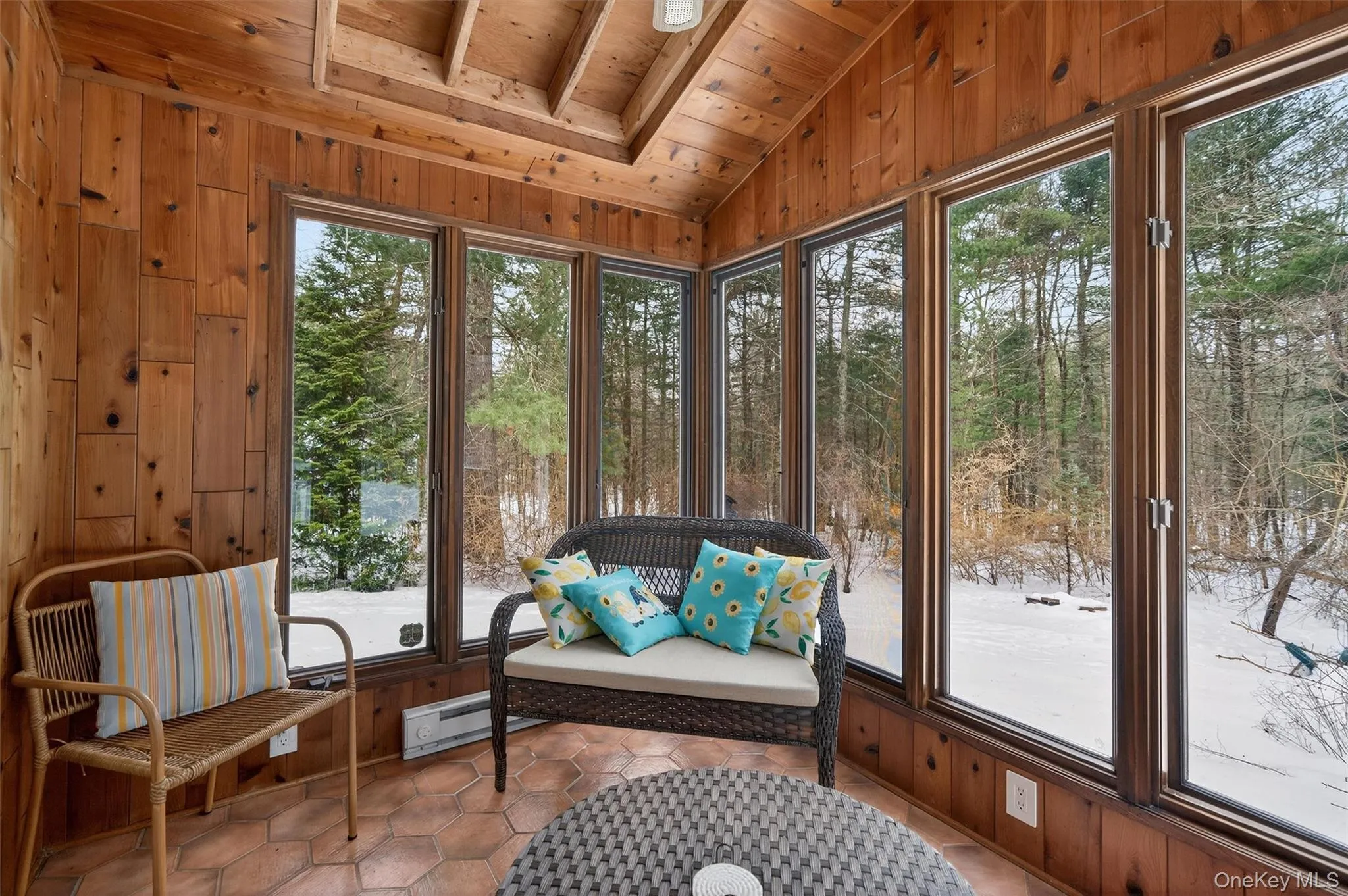 Sunroom / solarium featuring lofted ceiling and view of scattered trees Sunroom / solarium featuring lofted ceiling and view of scattered trees
