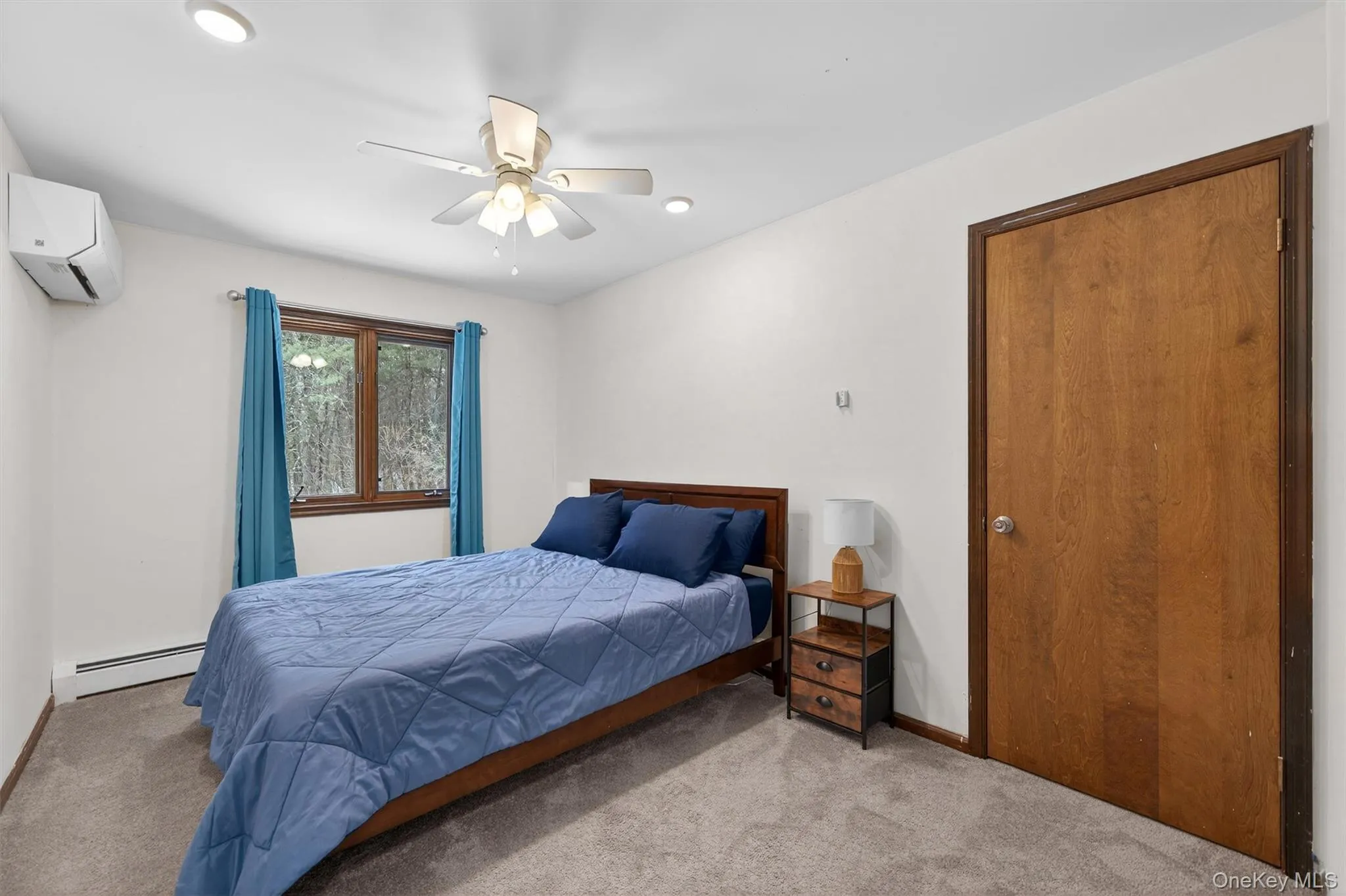 Carpeted bedroom featuring a baseboard radiator and a ceiling fan Carpeted bedroom featuring a baseboard radiator and a ceiling fan