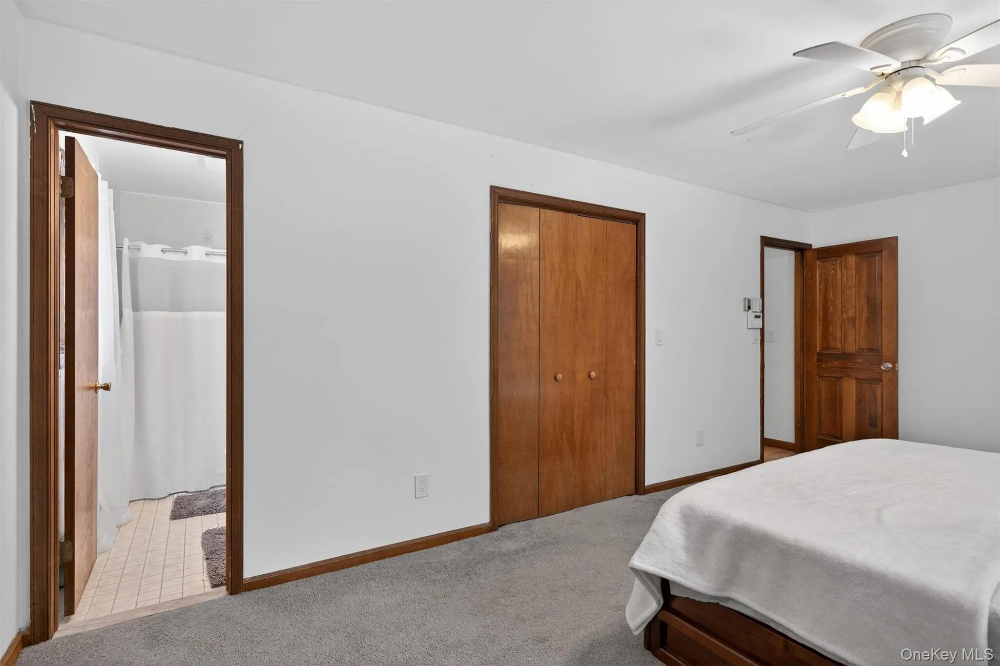 Carpeted bedroom featuring a closet and a ceiling fan Carpeted bedroom featuring a closet and a ceiling fan