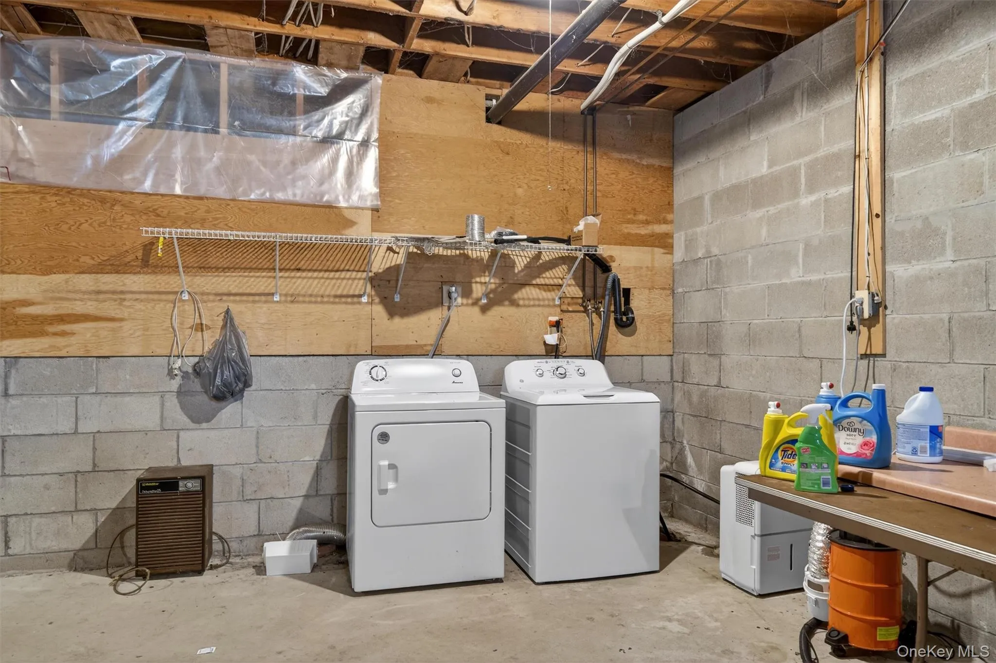 Laundry area featuring unfinished concrete flooring and washer and dryer Laundry area featuring unfinished concrete flooring and washer and dryer