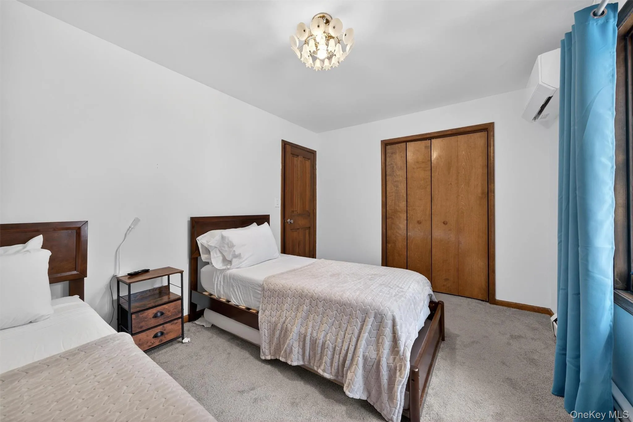 Carpeted bedroom with a closet, a mini split for heating / cooling, and hanging lights Carpeted bedroom with a closet, a mini split for heating / cooling, and hanging lights