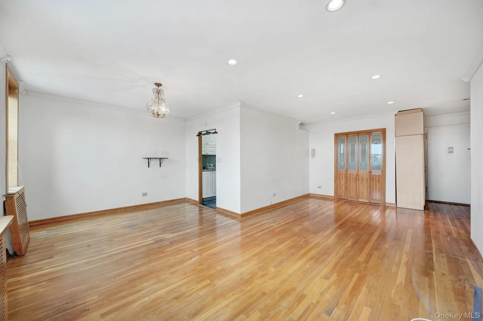Featuring light wood-style floors, crown molding, and a chandelier Featuring light wood-style floors, crown molding, and a chandelier