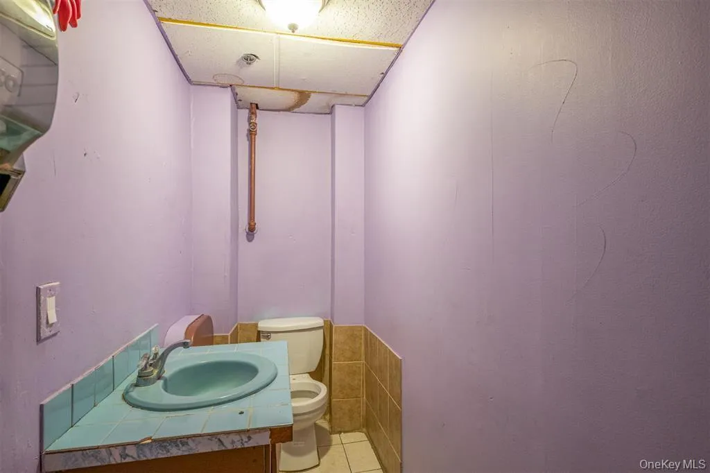 Half bathroom featuring vanity and light tile patterned floors Half bathroom featuring vanity and light tile patterned floors