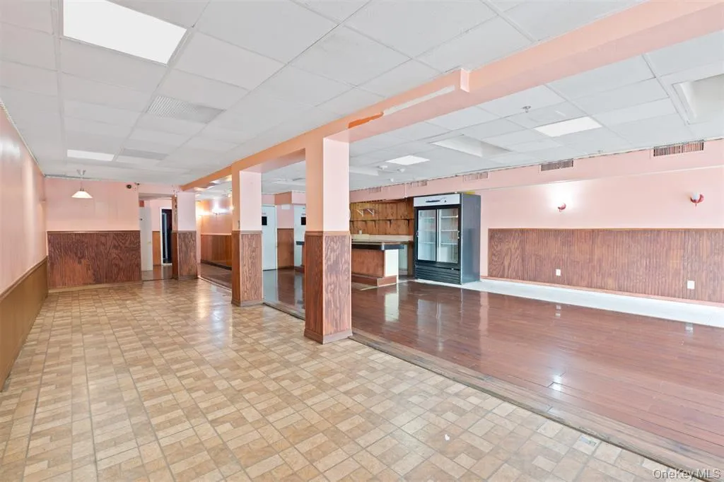 Reception area featuring wainscoting, wooden walls, and a paneled ceiling Reception area featuring wainscoting, wooden walls, and a paneled ceiling