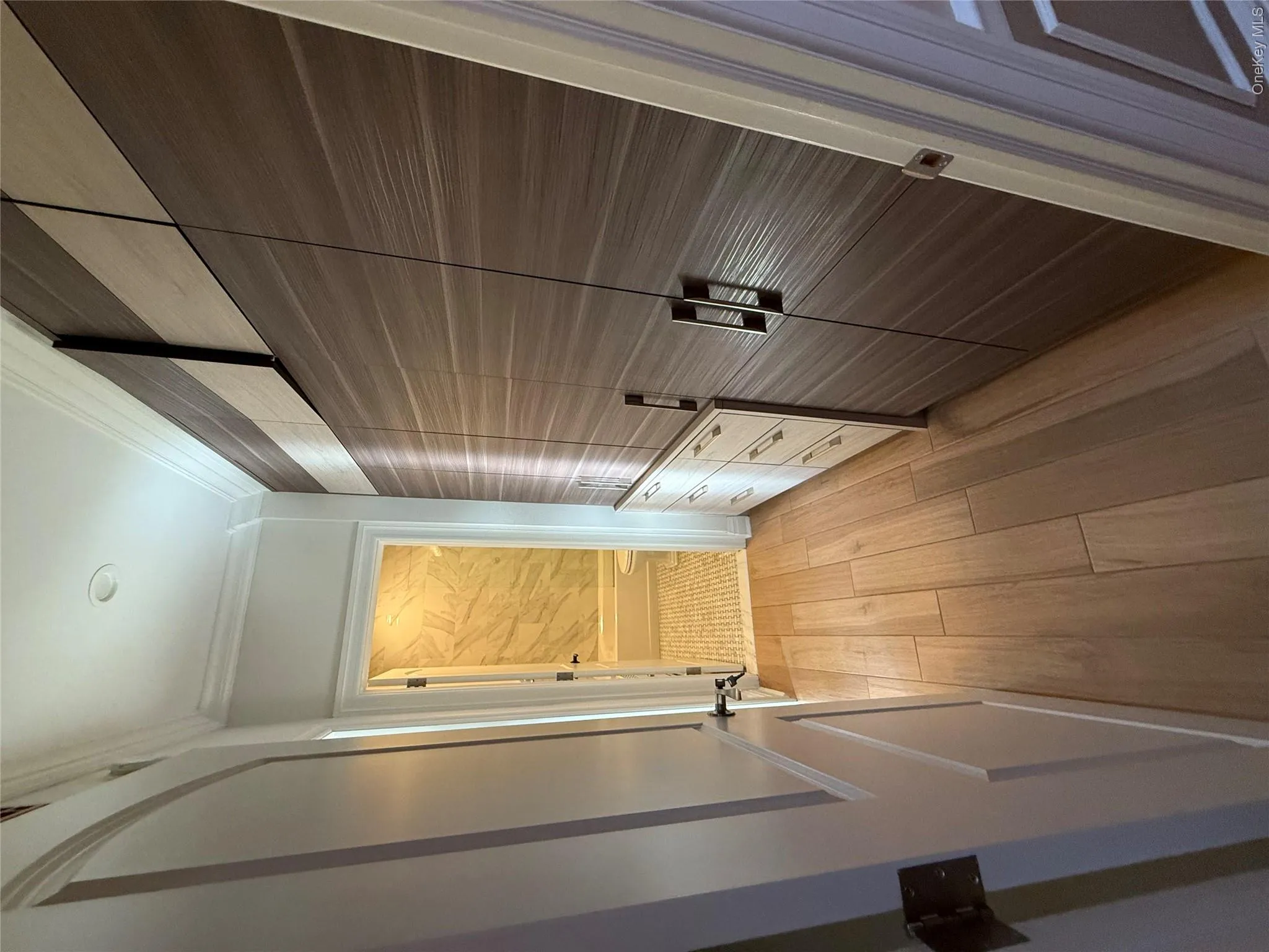 Hall with ornamental molding and light wood-style flooring Hall with ornamental molding and light wood-style flooring