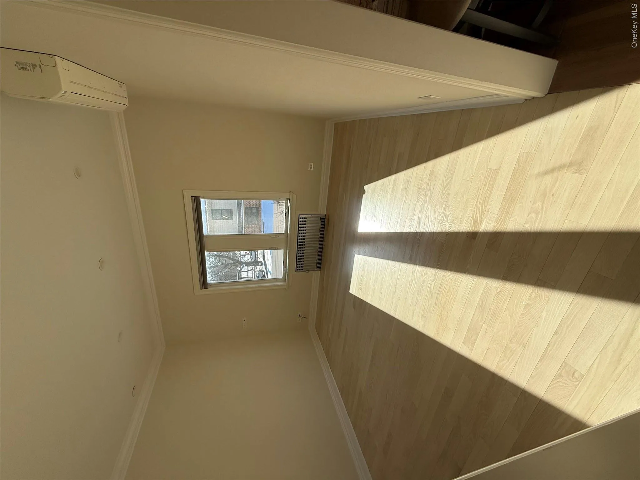Empty room with light wood-style flooring, radiator heating unit, and crown molding Empty room with light wood-style flooring, radiator heating unit, and crown molding