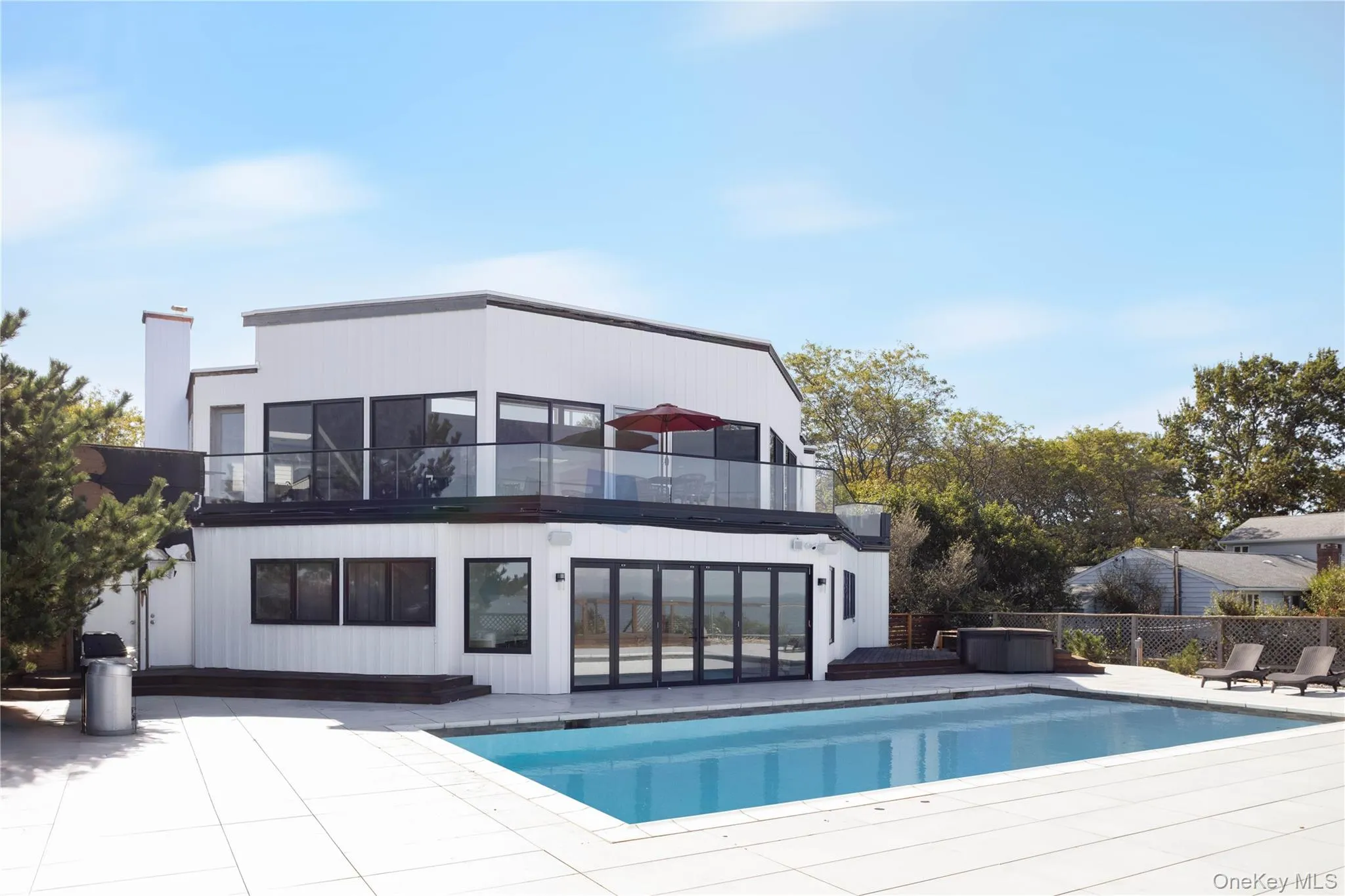 Rear view of property featuring a patio, a fenced in pool, a chimney, and a balcony Rear view of property featuring a patio, a fenced in pool, a chimney, and a balcony