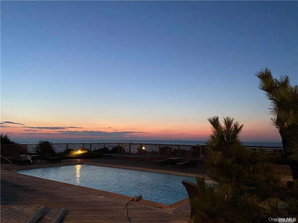 Pool at dusk with an outdoor pool and fence Pool at dusk with an outdoor pool and fence