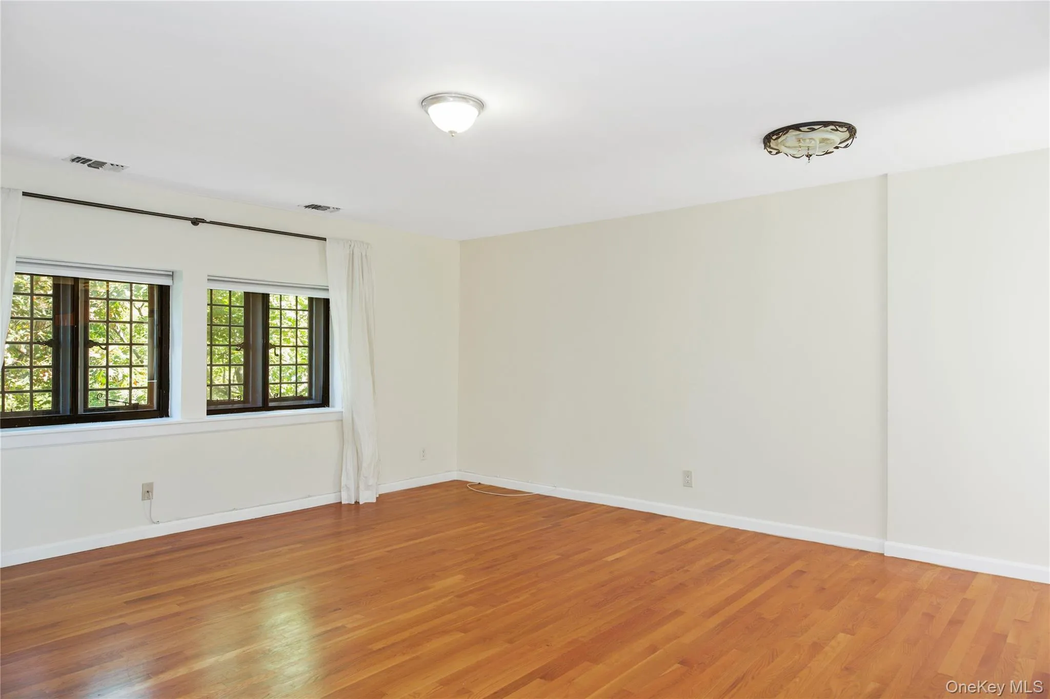 Unfurnished room featuring light wood finished floors and baseboards Unfurnished room featuring light wood finished floors and baseboards