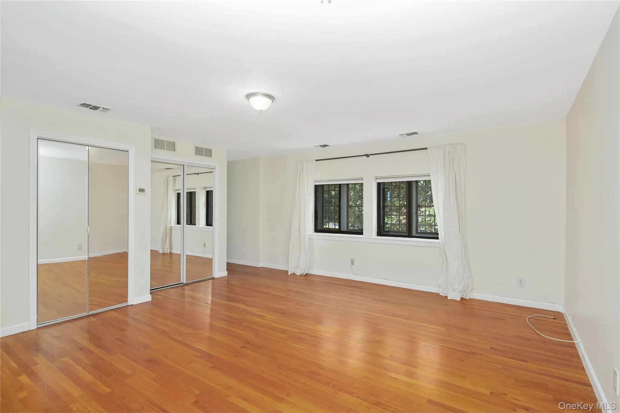 Unfurnished bedroom featuring two closets and light wood-style floors Unfurnished bedroom featuring two closets and light wood-style floors
