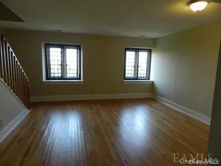 Spare room with a healthy amount of sunlight and wood-type flooring Spare room with a healthy amount of sunlight and wood-type flooring