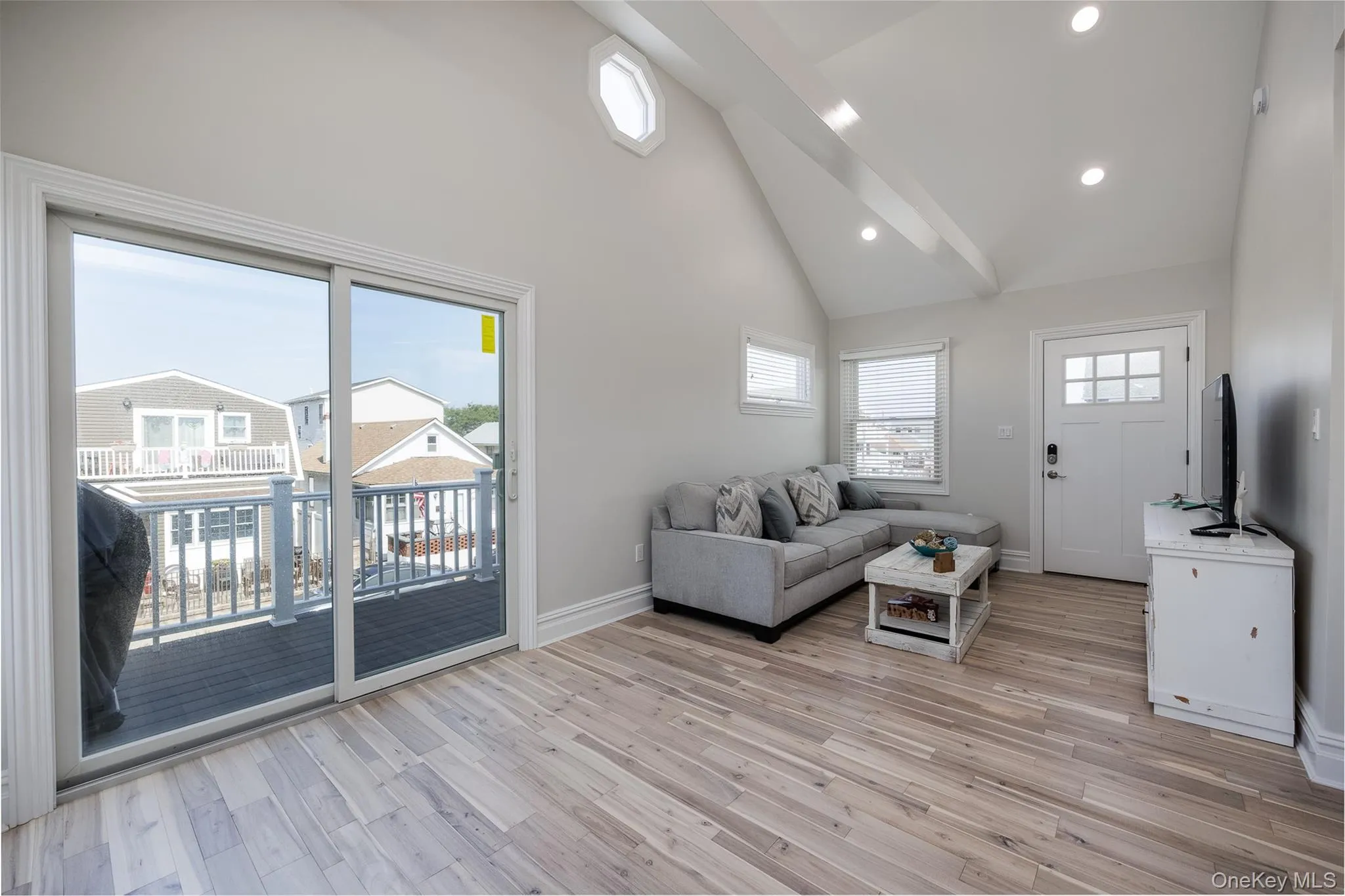 Living room with vaulted ceilings and porcelain tile wood flooring Living room with vaulted ceilings and porcelain tile wood flooring