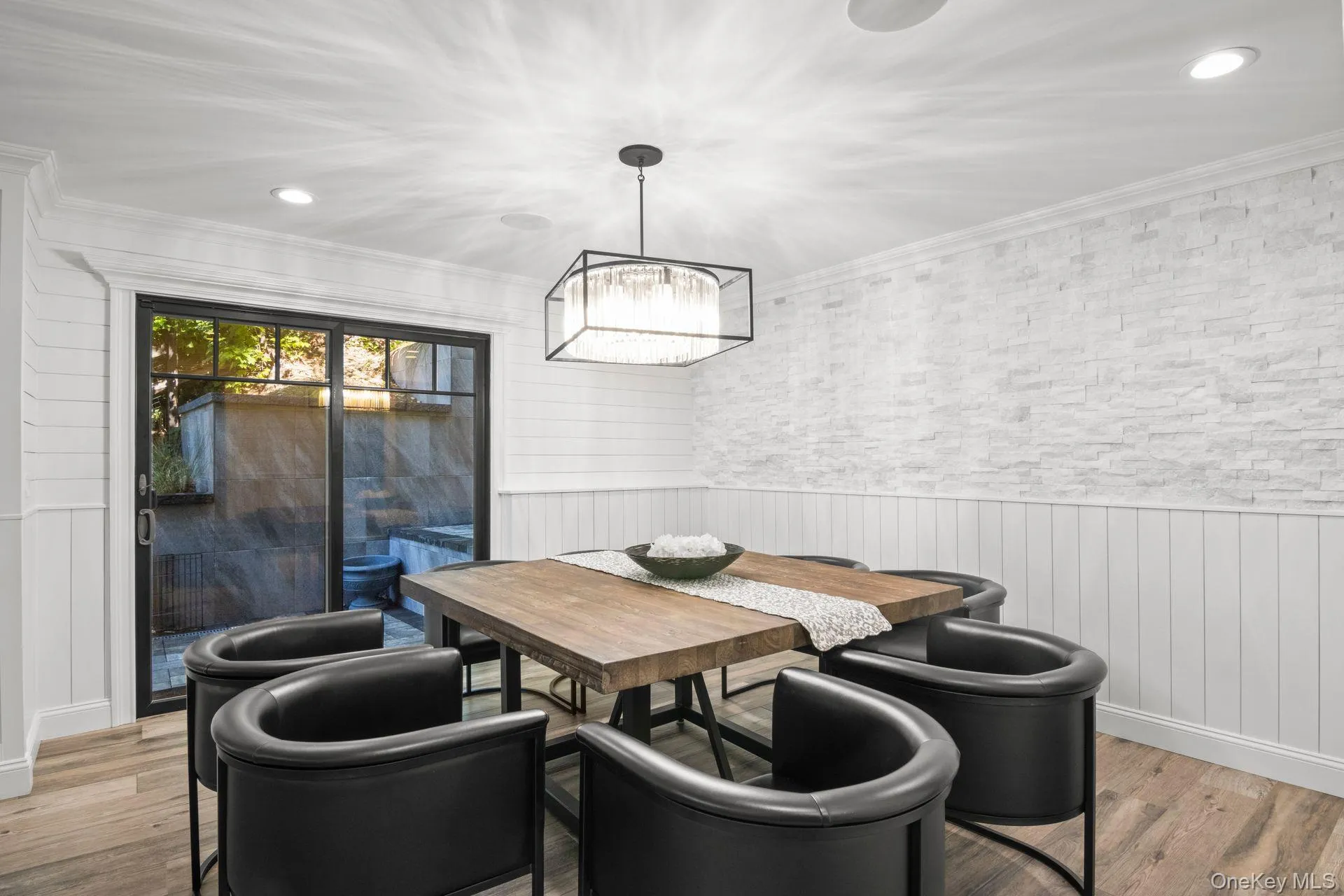 Dining room featuring Shiplap wainscotting and doors to a side patio Dining room featuring Shiplap wainscotting and doors to a side patio