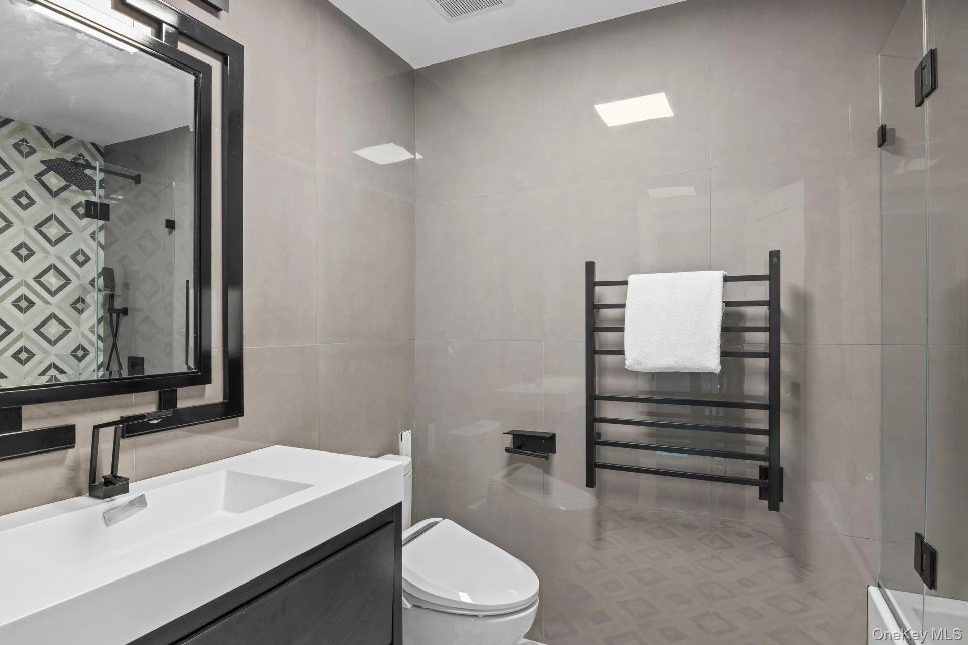 Second Floor Bathroom featuring tile walls, radiator, vanity, a stall shower, and a towel warming rack Second Floor Bathroom featuring tile walls, radiator, vanity, a stall shower, and a towel warming rack