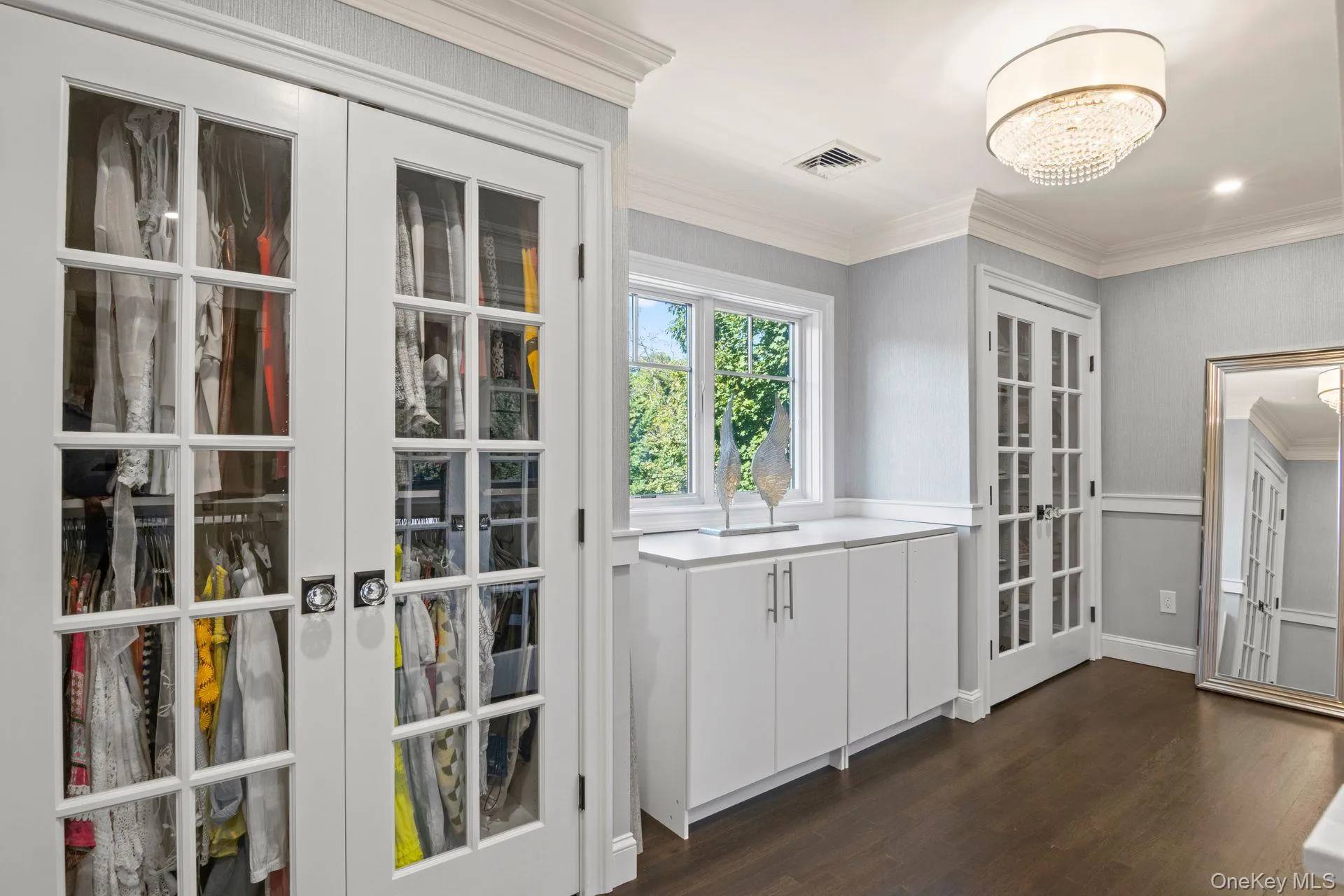 Primary Suite Bespoke walk-in closet with custom closets with French doors Primary Suite Bespoke walk-in closet with custom closets with French doors
