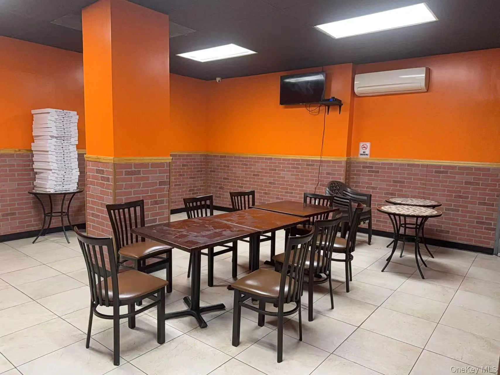 Dining space featuring an AC wall unit and light tile patterned floors Dining space featuring an AC wall unit and light tile patterned floors