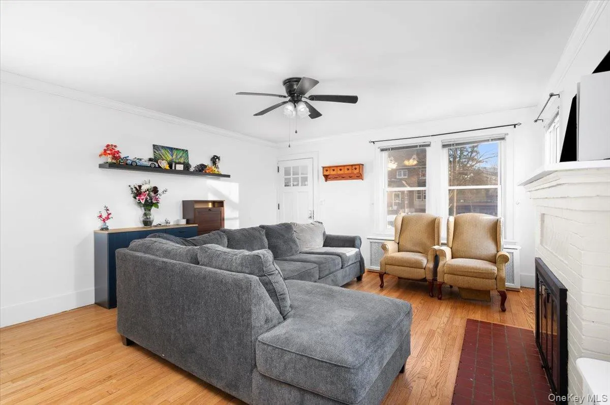 Living area featuring light wood-style floors, crown molding, a ceiling fan Living area featuring light wood-style floors, crown molding, a ceiling fan