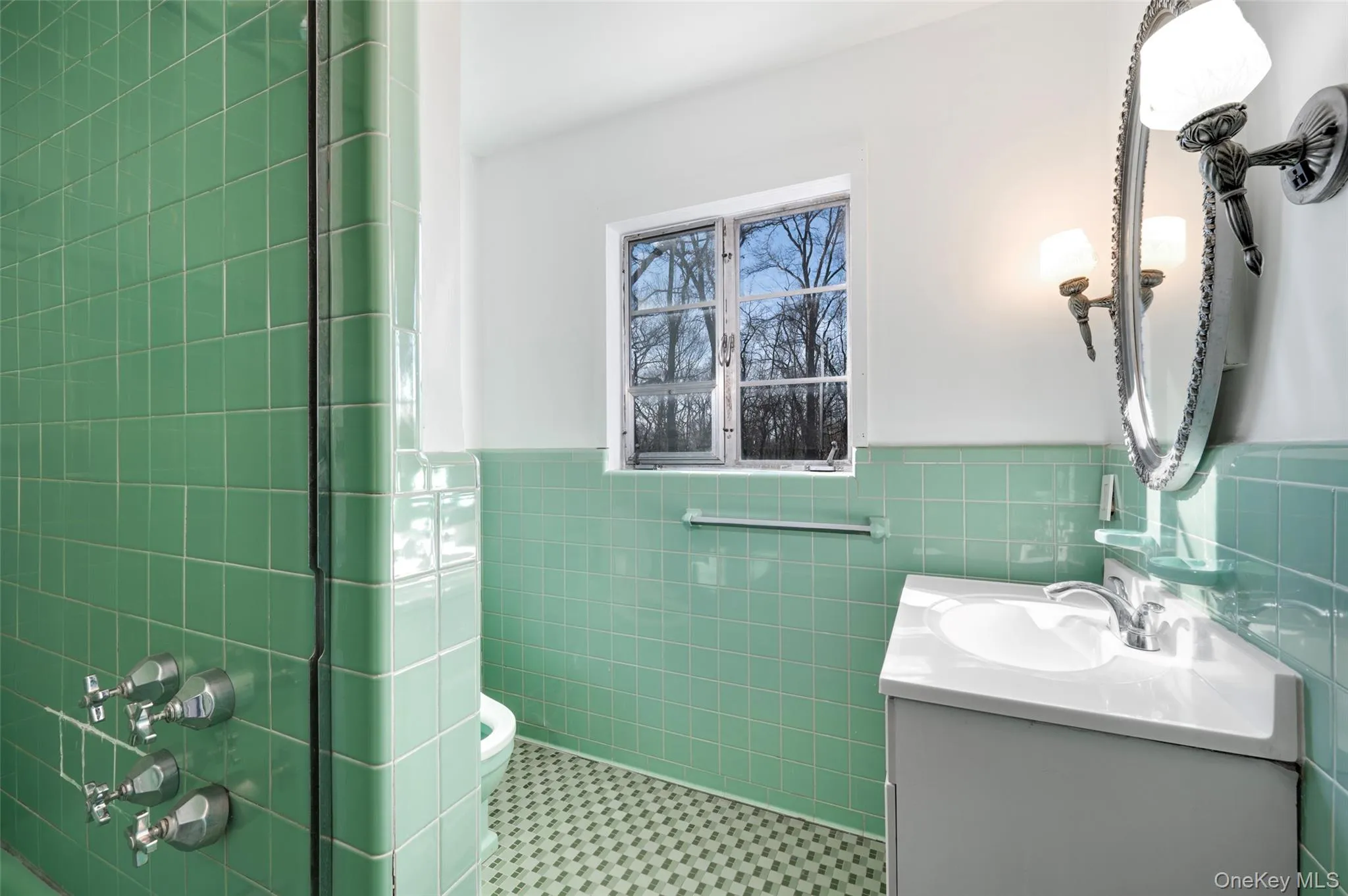 Bathroom with tile patterned floors, vanity, toilet, and tile walls Bathroom with tile patterned floors, vanity, toilet, and tile walls