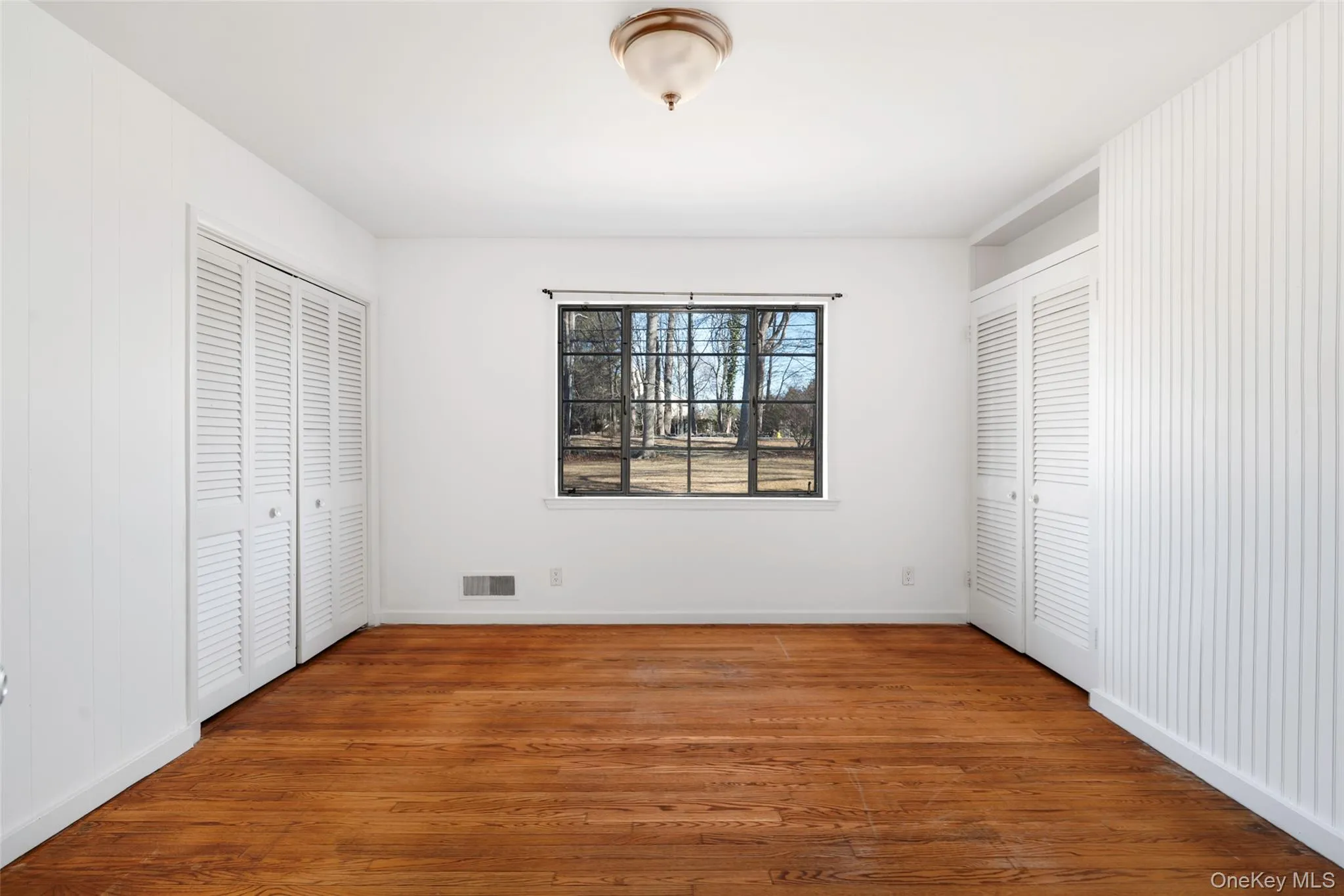 Unfurnished bedroom with hardwood / wood-style flooring Unfurnished bedroom with hardwood / wood-style flooring