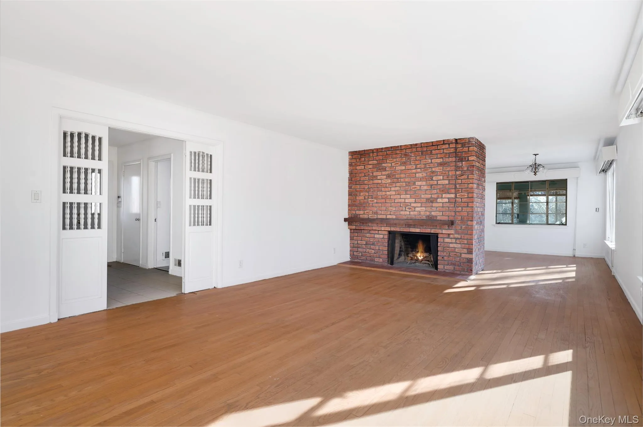 Unfurnished living room featuring a fireplace and light hardwood / wood-style flooring Unfurnished living room featuring a fireplace and light hardwood / wood-style flooring