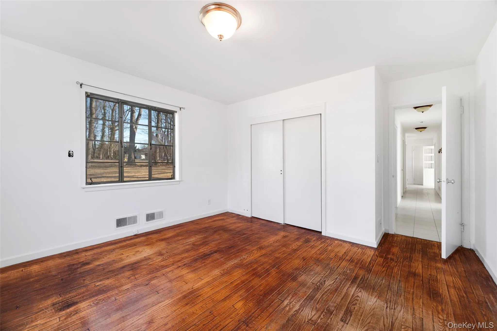 Unfurnished bedroom featuring a closet and dark hardwood / wood-style floors Unfurnished bedroom featuring a closet and dark hardwood / wood-style floors