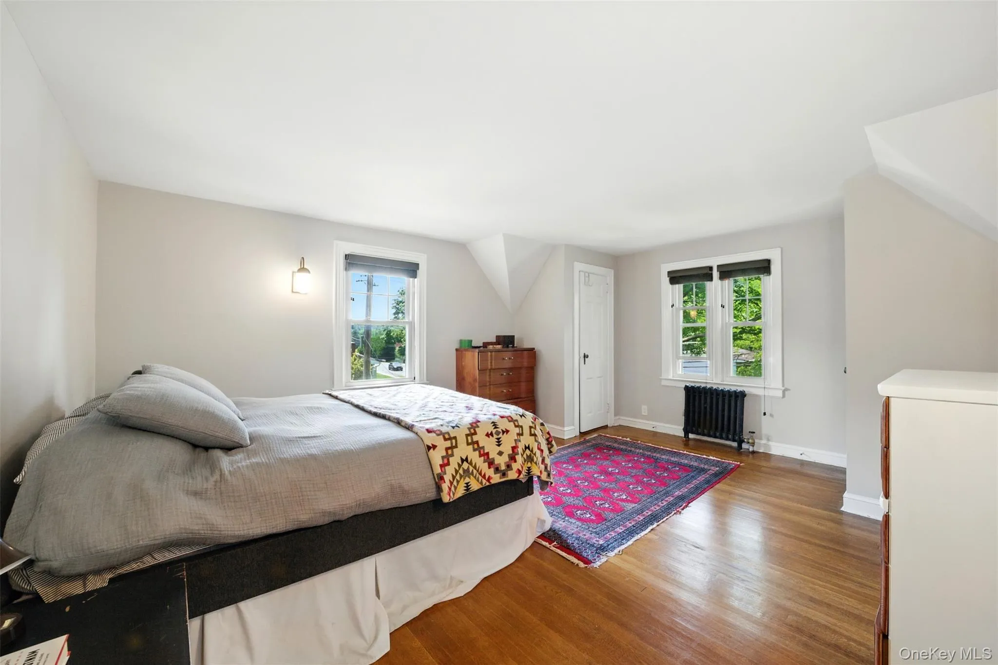 Bedroom featuring radiator and wood finished floors Bedroom featuring radiator and wood finished floors