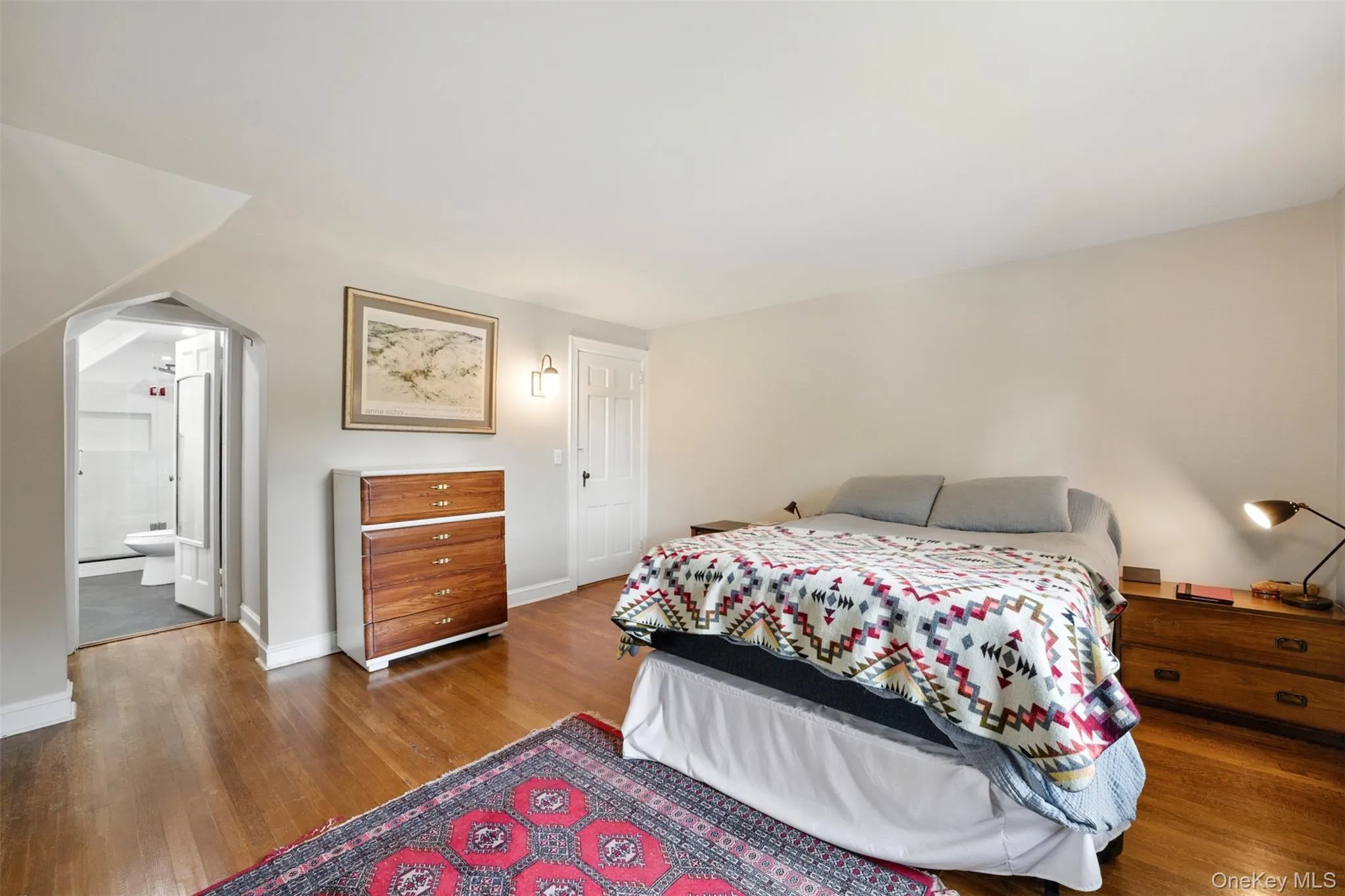 2nd Bedroom which is the Primary Bedroom featuring wood floors, arched walkways, and ensuite bathroom 2nd Bedroom which is the Primary Bedroom featuring wood floors, arched walkways, and ensuite bathroom