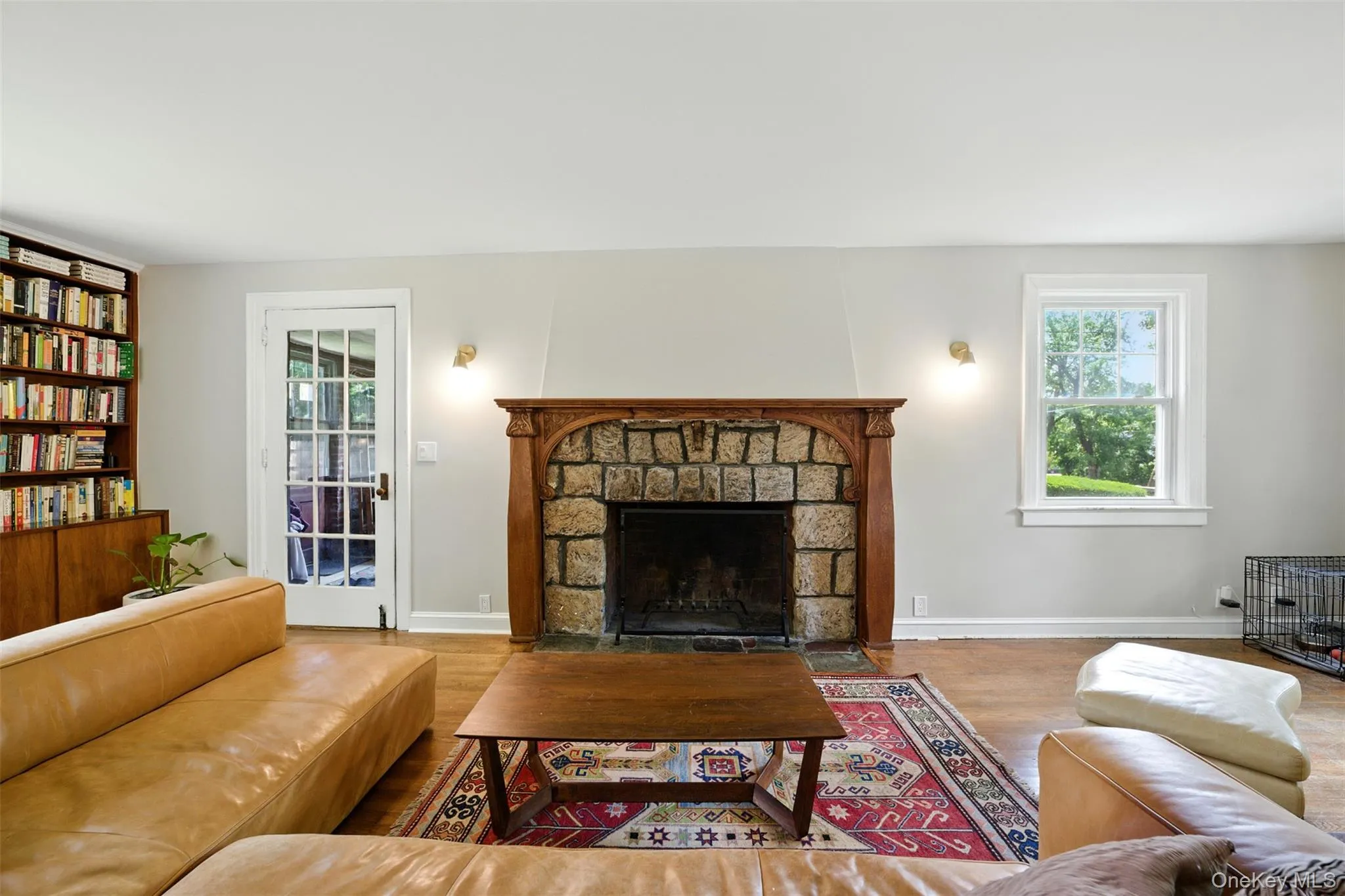 Living room featuring wood finished floors and a stone fireplace Living room featuring wood finished floors and a stone fireplace