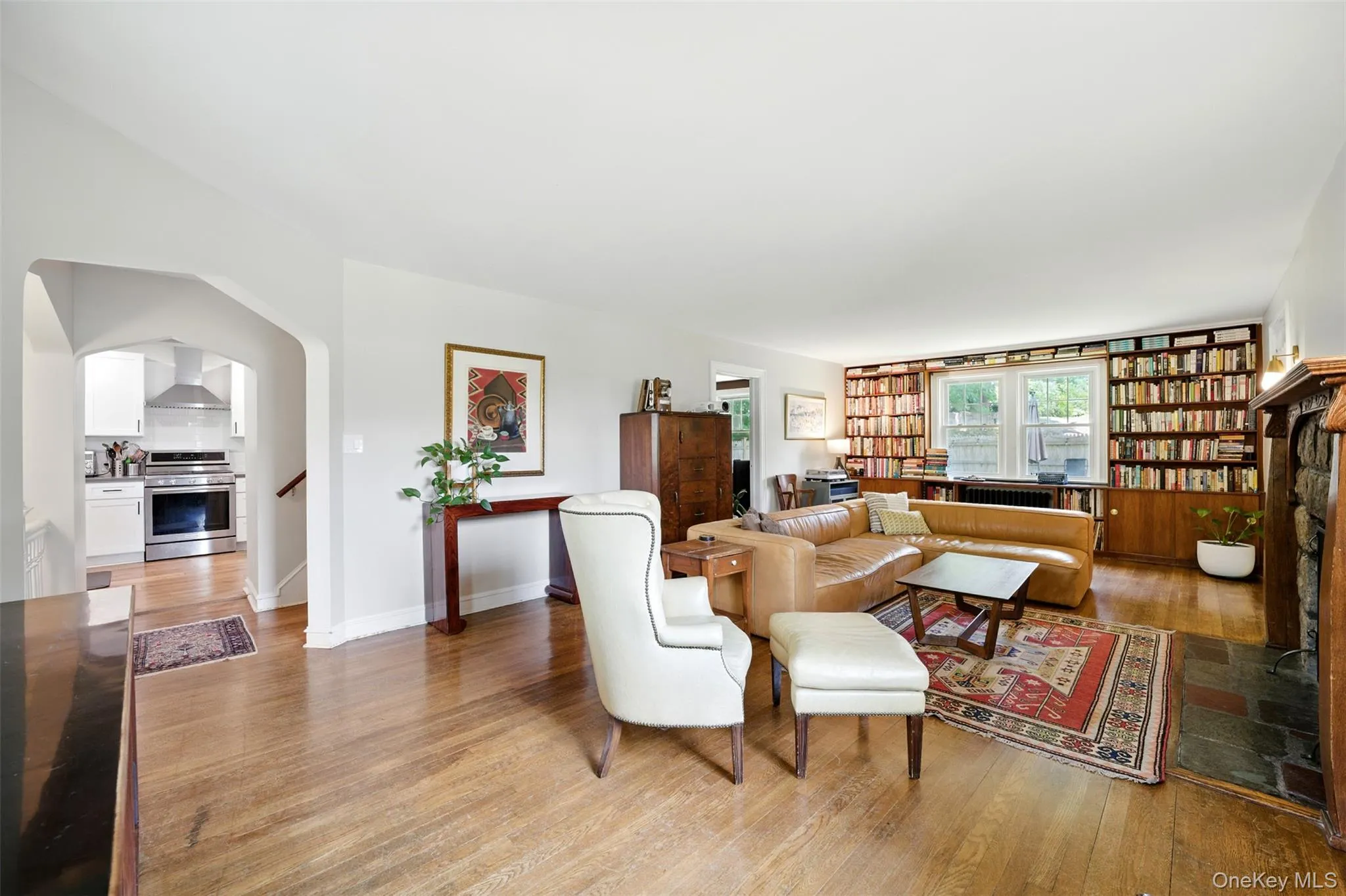Living area with light wood-type flooring, arched walkways, and stairs Living area with light wood-type flooring, arched walkways, and stairs