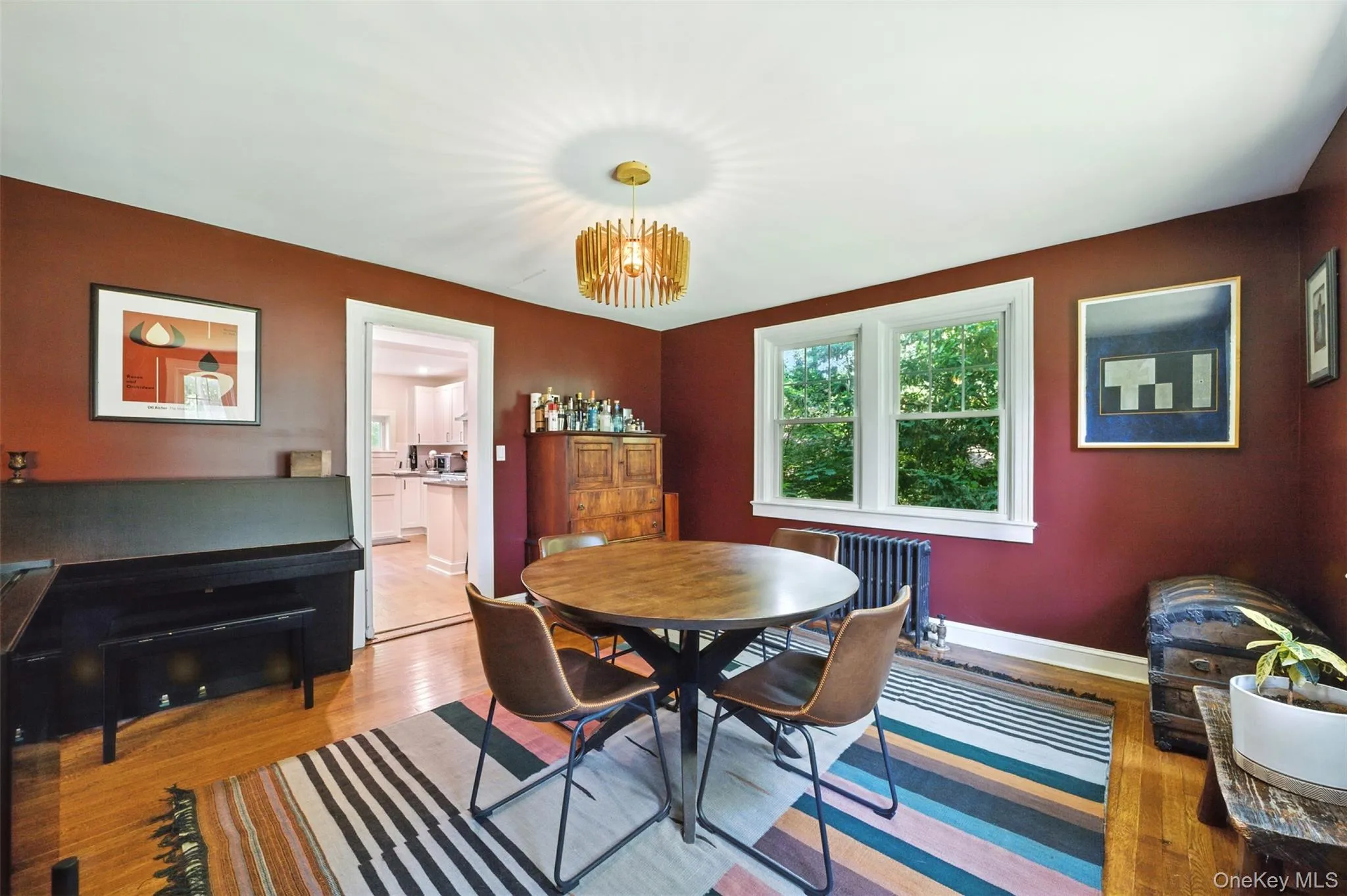 Dining area featuring radiator, a chandelier, and light wood-type flooring Dining area featuring radiator, a chandelier, and light wood-type flooring