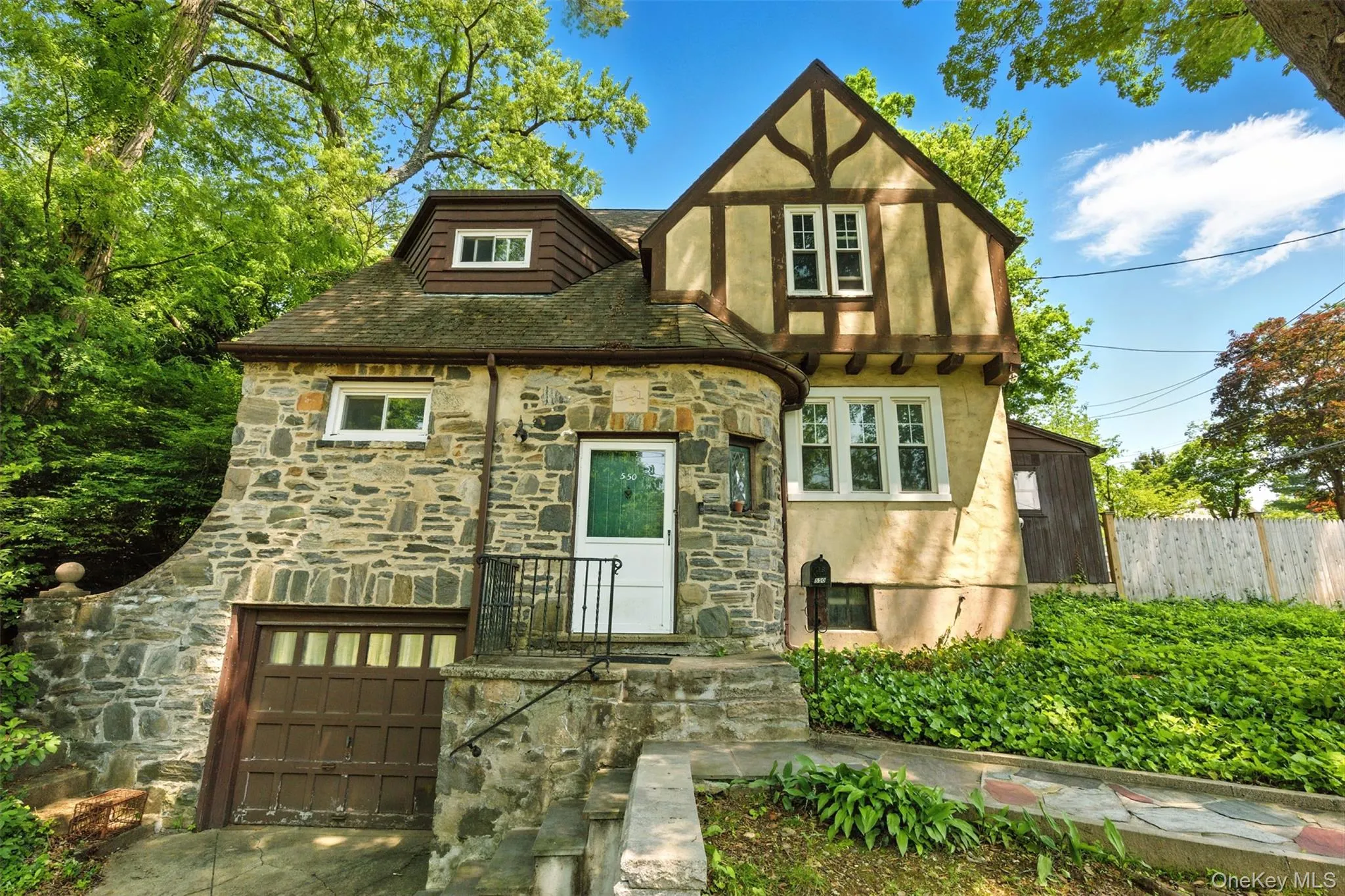 English style home featuring stone siding and stucco siding English style home featuring stone siding and stucco siding