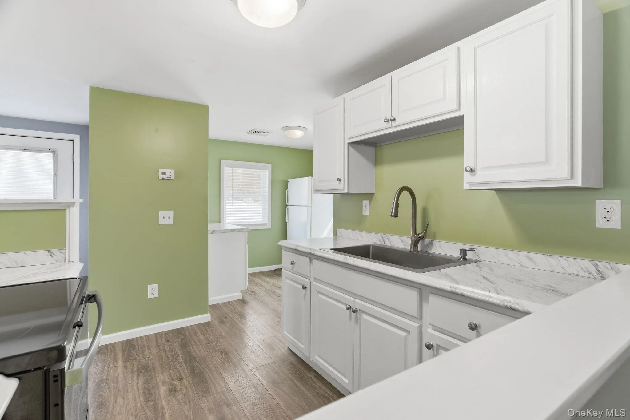 Bright kitchen area with sink and marble look countertops Bright kitchen area with sink and marble look countertops