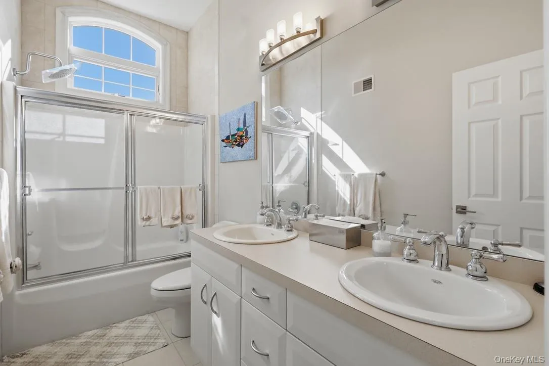 This full bathroom offers a double-sink vanity, tub and shower. This full bathroom offers a double-sink vanity, tub and shower.