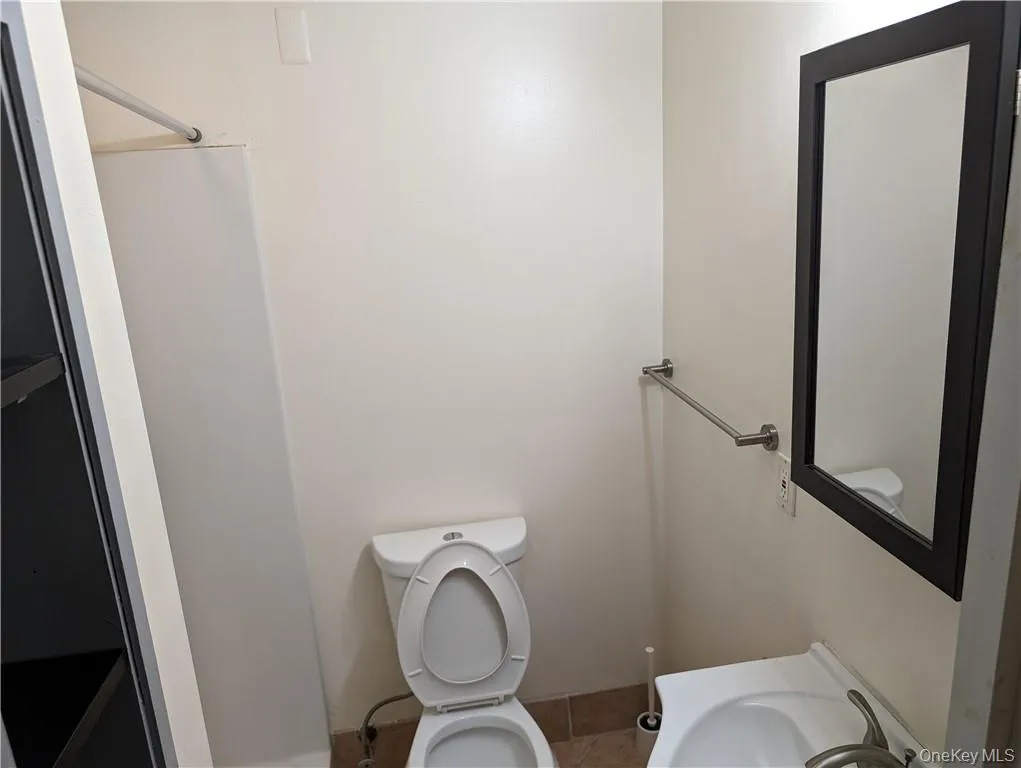 Bathroom featuring sink, toilet, and tile floors Bathroom featuring sink, toilet, and tile floors