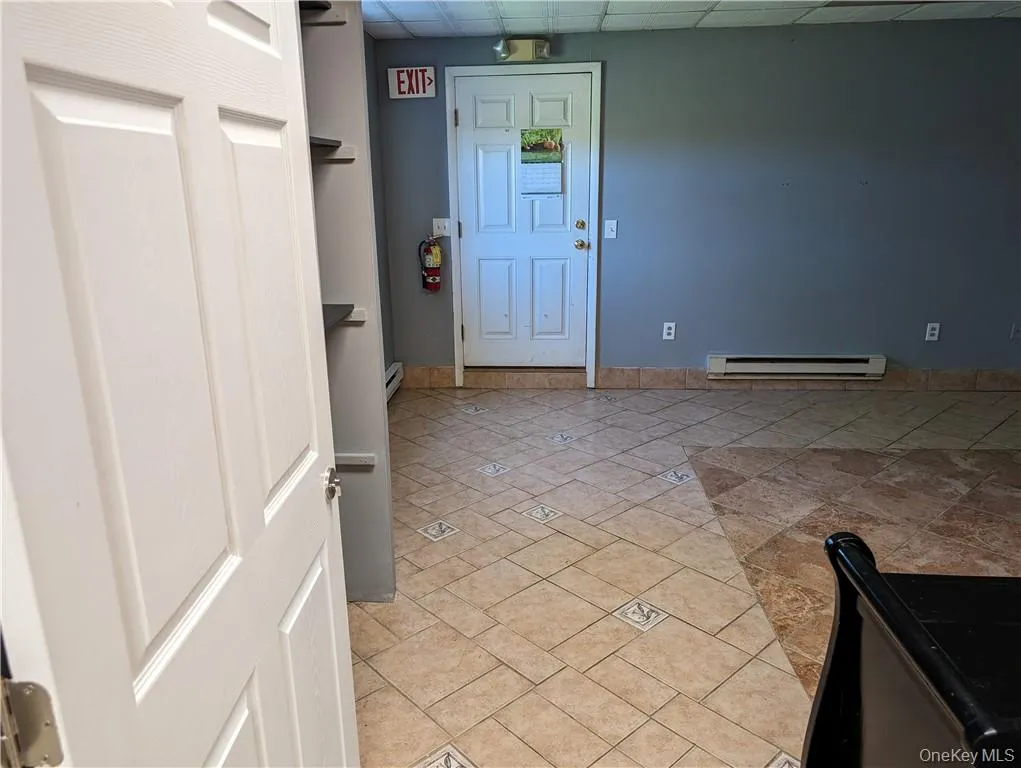 Beauty salon Entrance foyer featuring baseboard heating, a paneled ceiling, and light tile floors Beauty salon Entrance foyer featuring baseboard heating, a paneled ceiling, and light tile floors