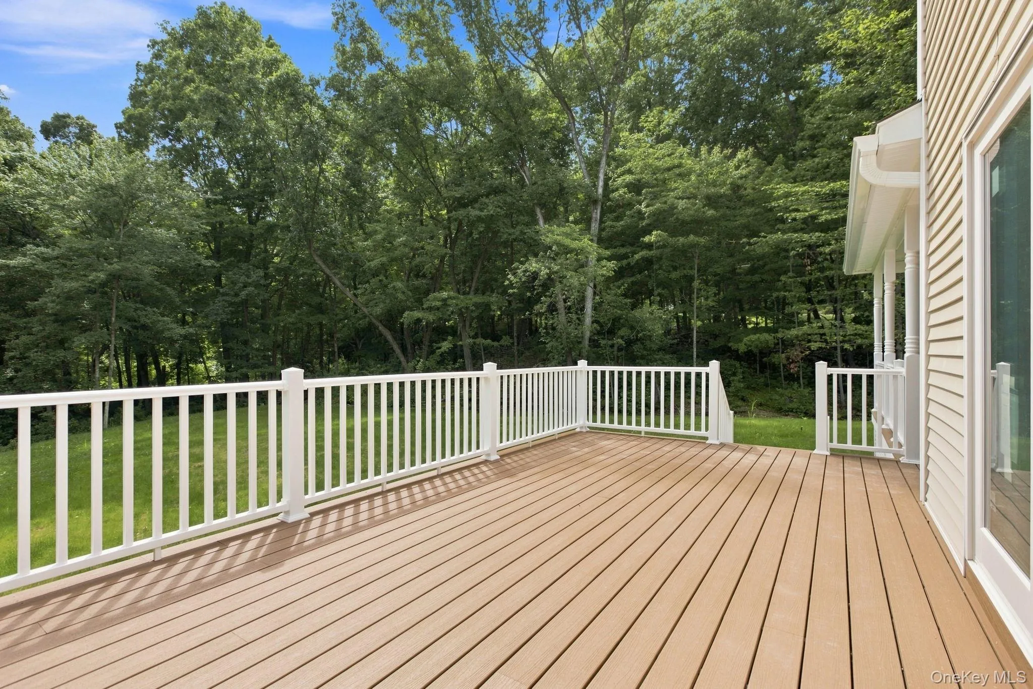 Trex deck overlooking the peaceful backyard with direct access to the kitchen—perfect for outdoor dining, entertaining, and effortless indoor-outdoor living Trex deck overlooking the peaceful backyard with direct access to the kitchen—perfect for outdoor dining, entertaining, and effortless indoor-outdoor living