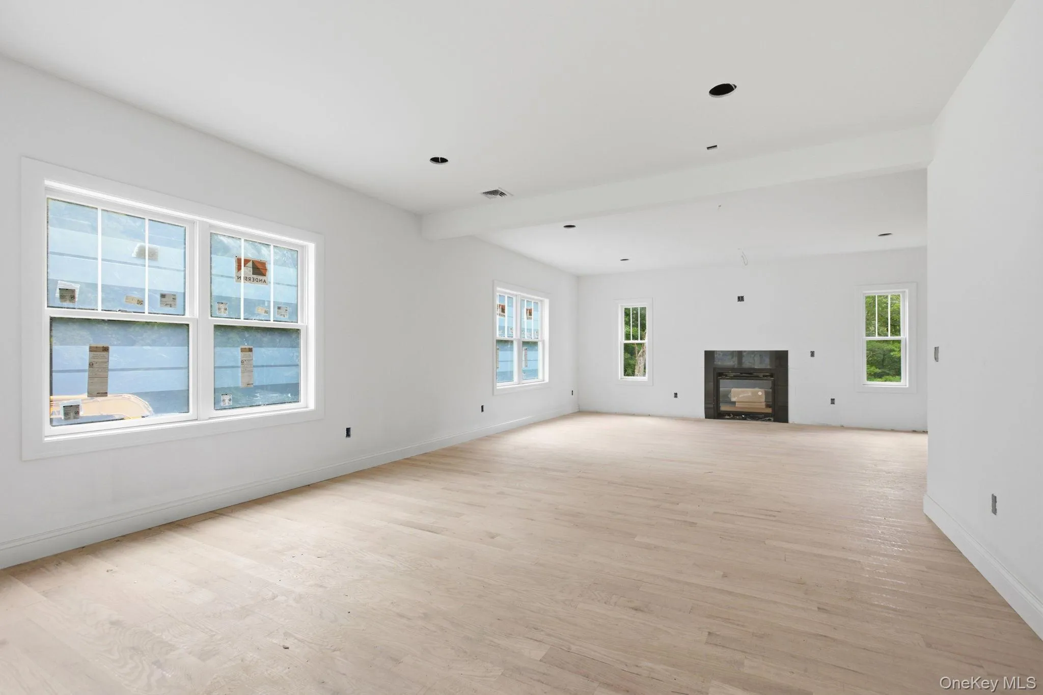Light-filled, expansive family room featuring a gas fireplace and hardwood floors, creating a warm and inviting gathering space at the heart of the home. Light-filled, expansive family room featuring a gas fireplace and hardwood floors, creating a warm and inviting gathering space at the heart of the home.