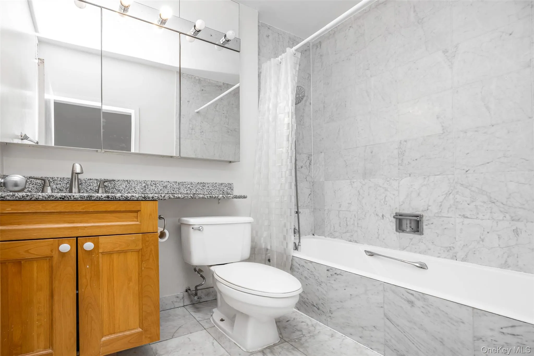 Full bathroom featuring vanity, tiled shower / bath, and toilet Full bathroom featuring vanity, tiled shower / bath, and toilet