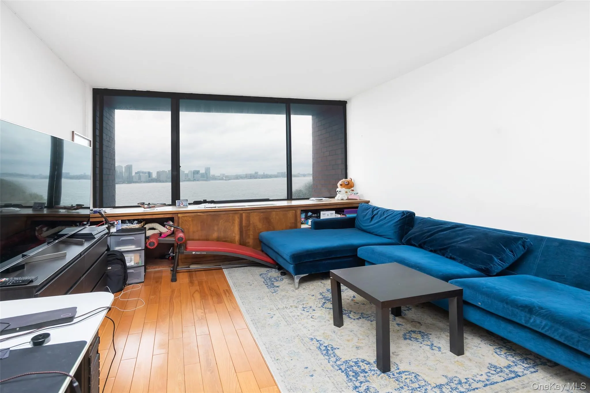 Living area with a water view, floor to ceiling windows, and hardwood / wood-style flooring Living area with a water view, floor to ceiling windows, and hardwood / wood-style flooring