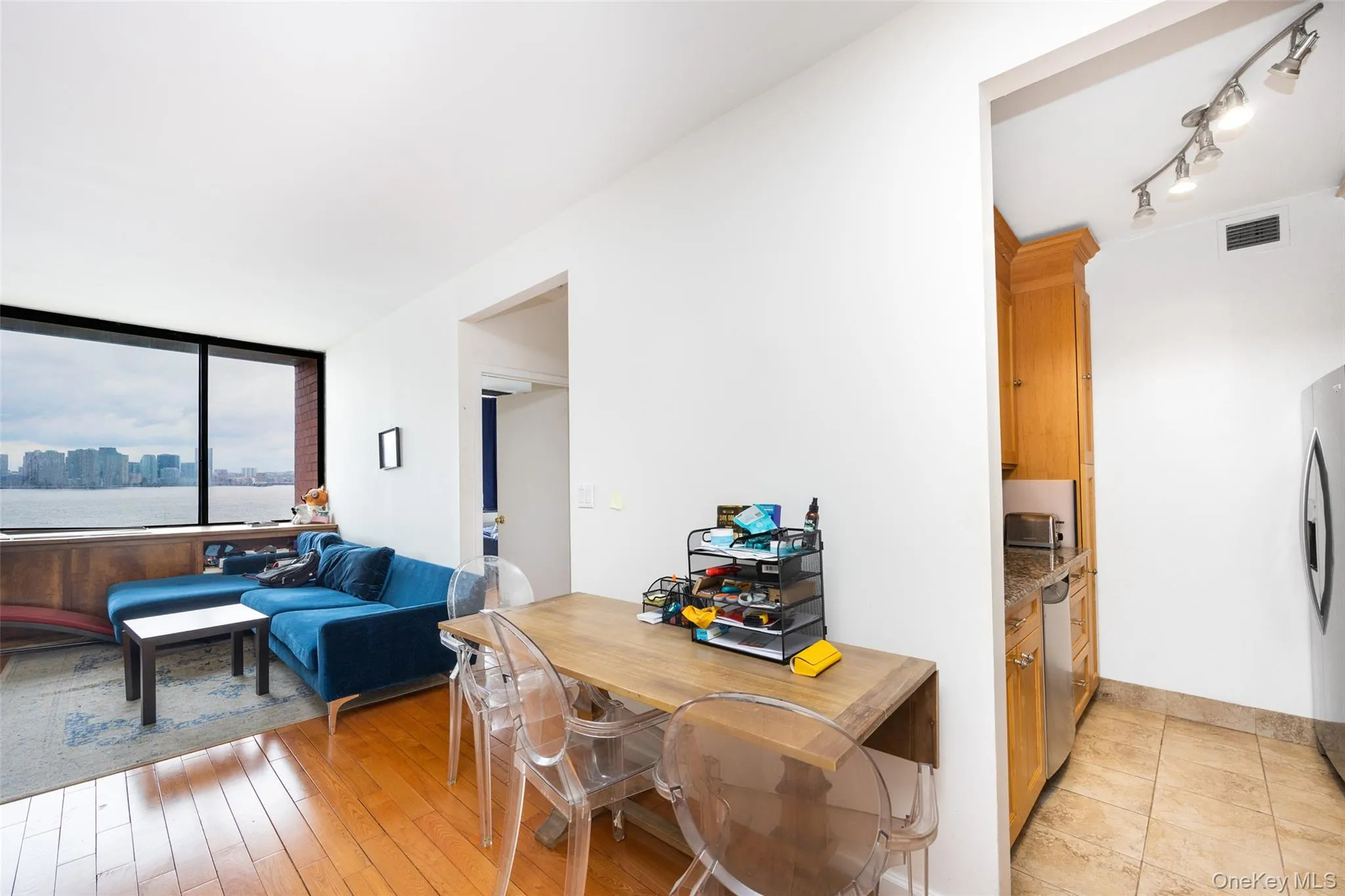 Kitchen with appliances with stainless steel finishes, light wood-type flooring, and visible vents Kitchen with appliances with stainless steel finishes, light wood-type flooring, and visible vents