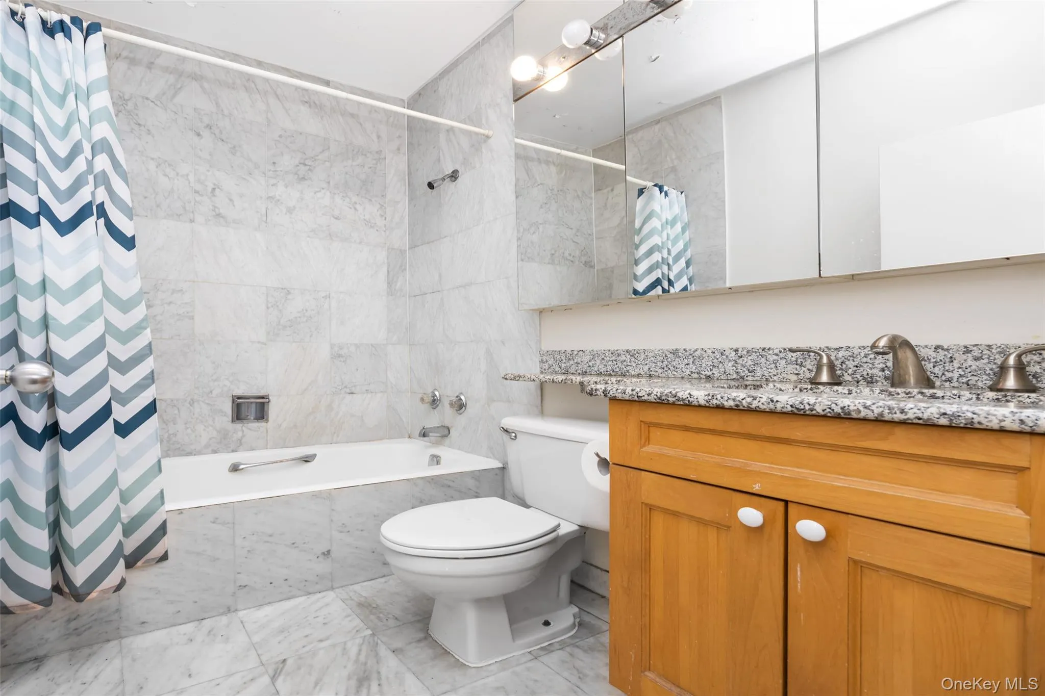 Bathroom featuring tiled shower / bath combo, toilet, and vanity Bathroom featuring tiled shower / bath combo, toilet, and vanity