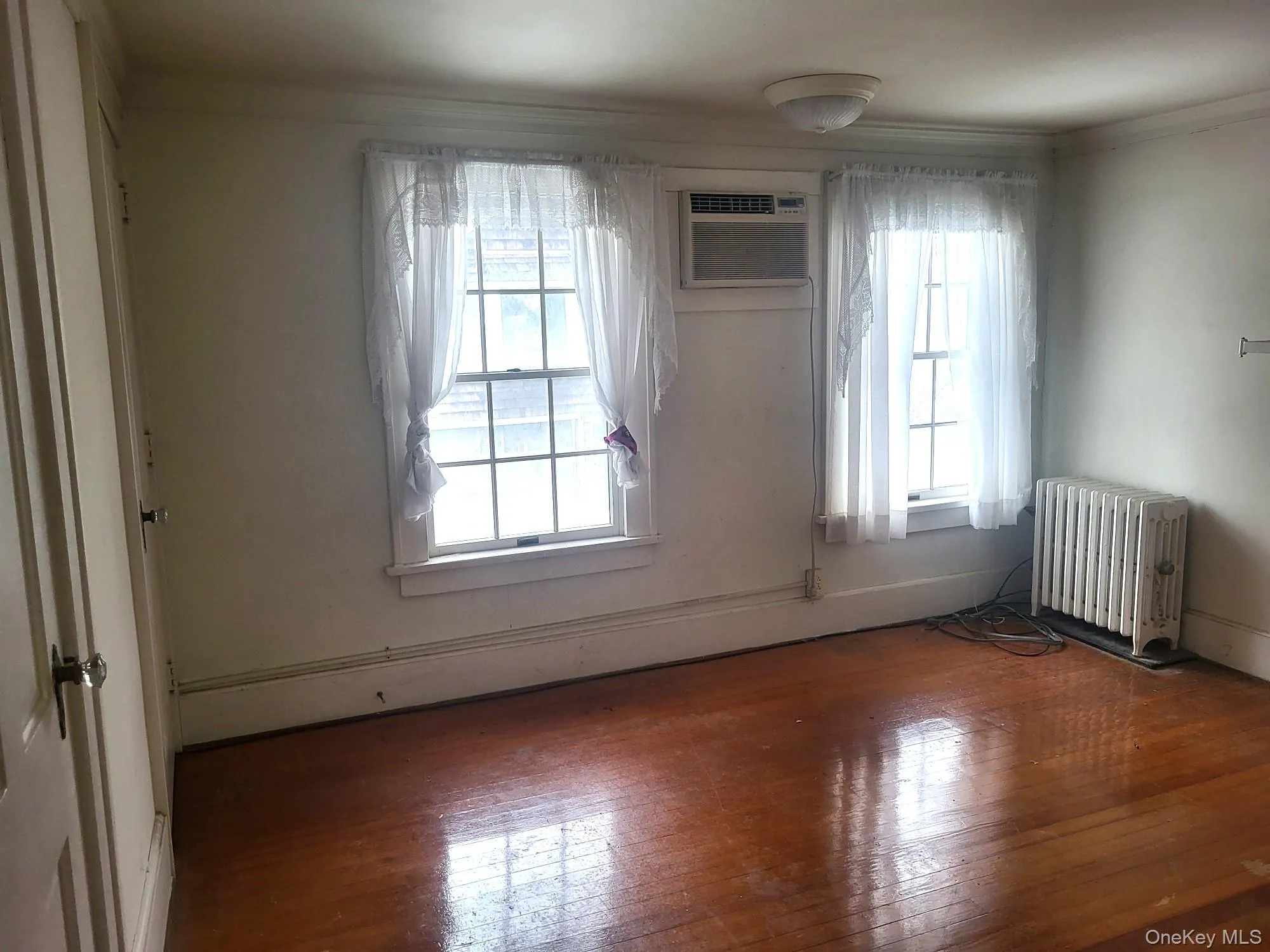 Primary bedroom with 2 closets, hardwood floors and wall A/C Primary bedroom with 2 closets, hardwood floors and wall A/C