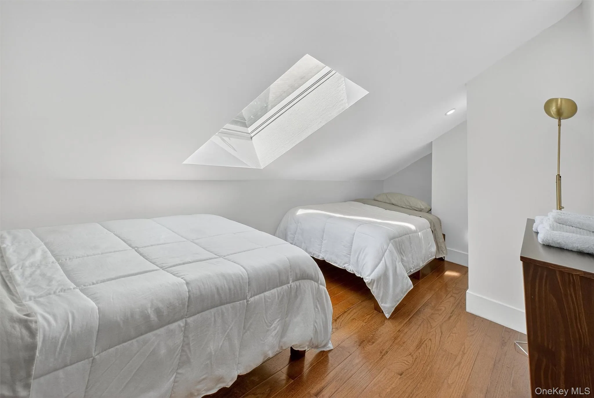 Bedroom with a skylight, wood finished floors, and lofted ceiling Bedroom with a skylight, wood finished floors, and lofted ceiling