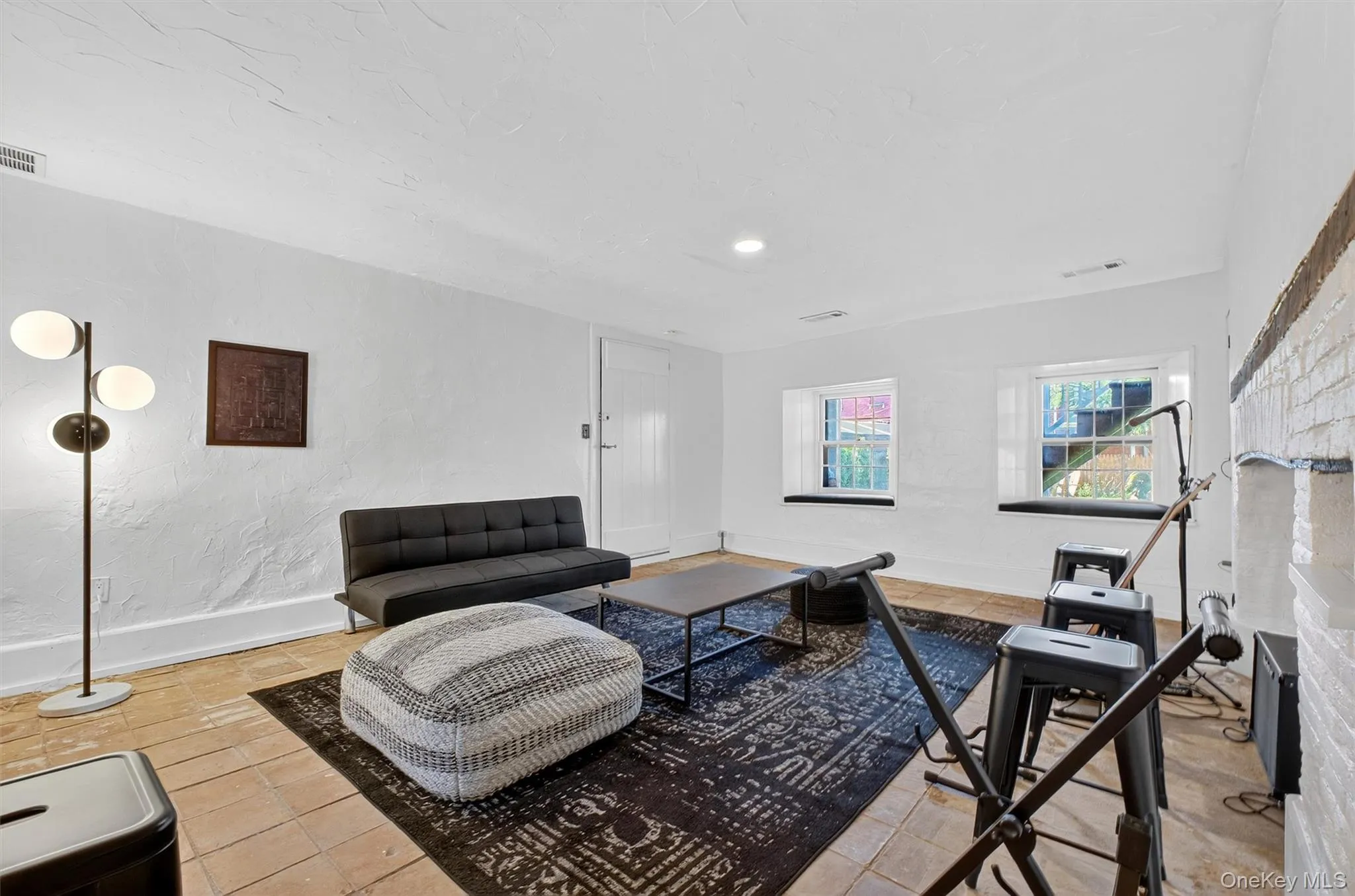 Tiled living room with recessed lighting and a textured wall Tiled living room with recessed lighting and a textured wall