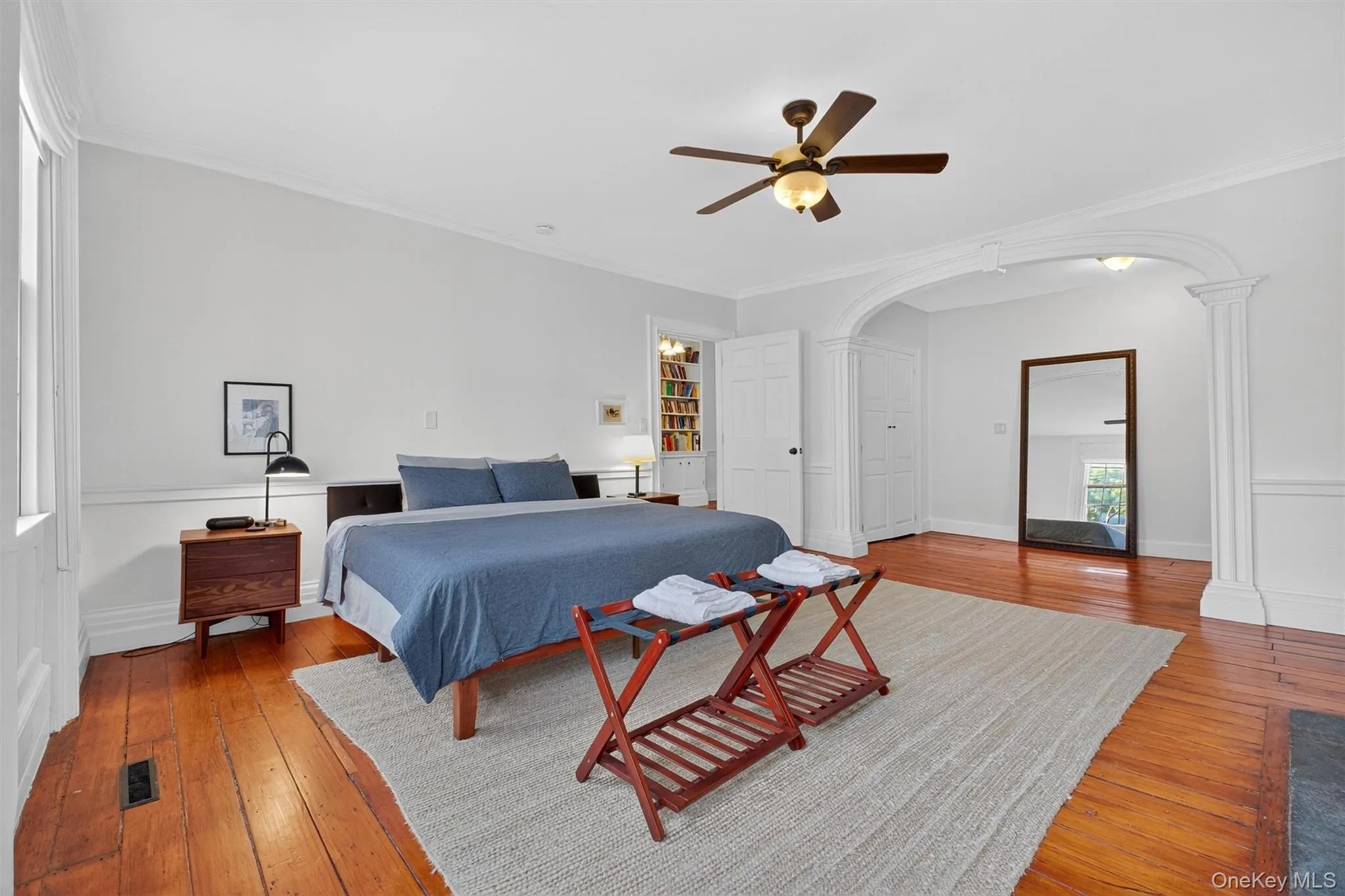 Bedroom with arched walkways, ornamental molding, hardwood / wood-style floors, and ceiling fan Bedroom with arched walkways, ornamental molding, hardwood / wood-style floors, and ceiling fan