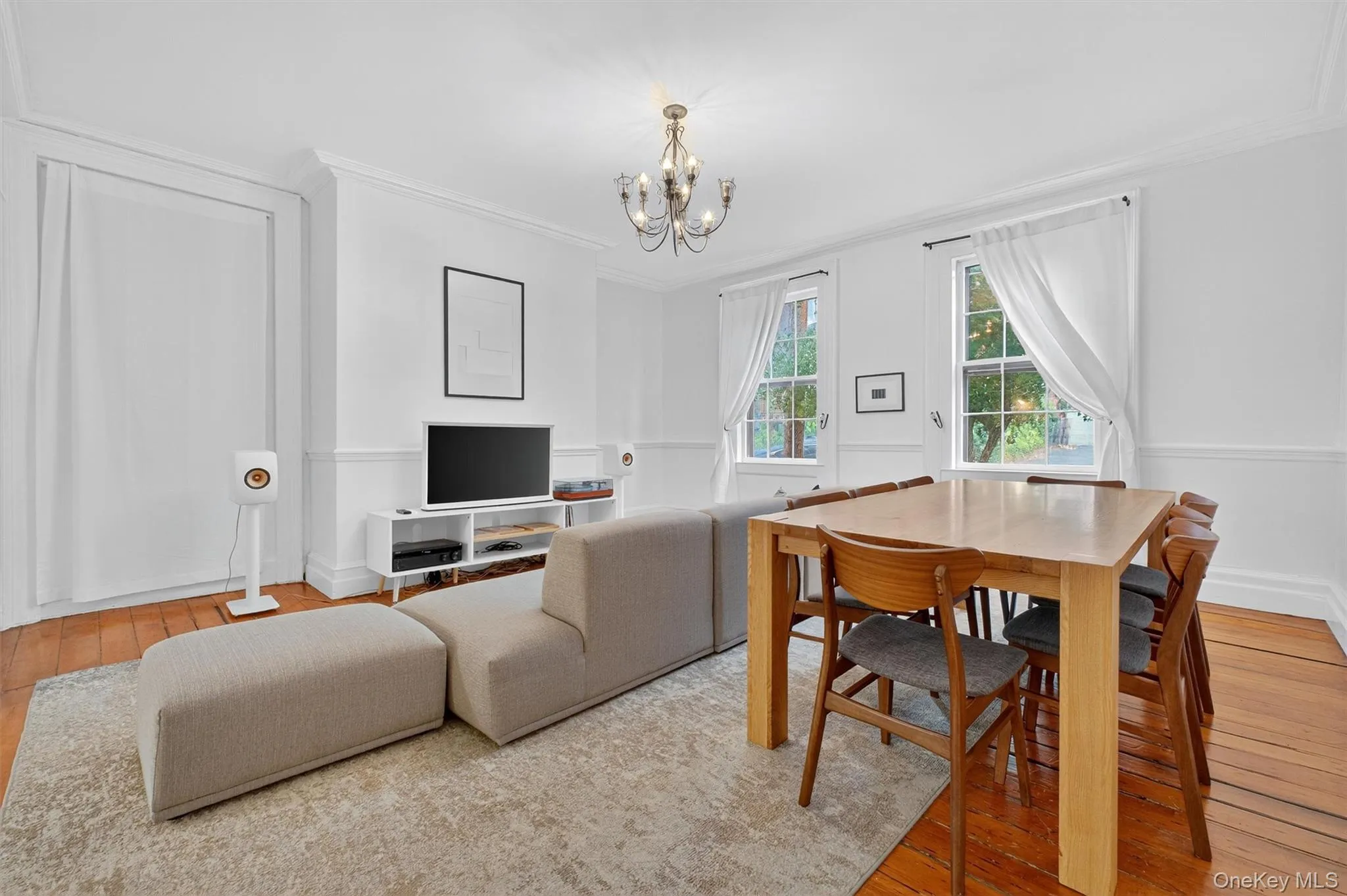 Living area with hardwood / wood-style floors, crown molding, and a chandelier Living area with hardwood / wood-style floors, crown molding, and a chandelier