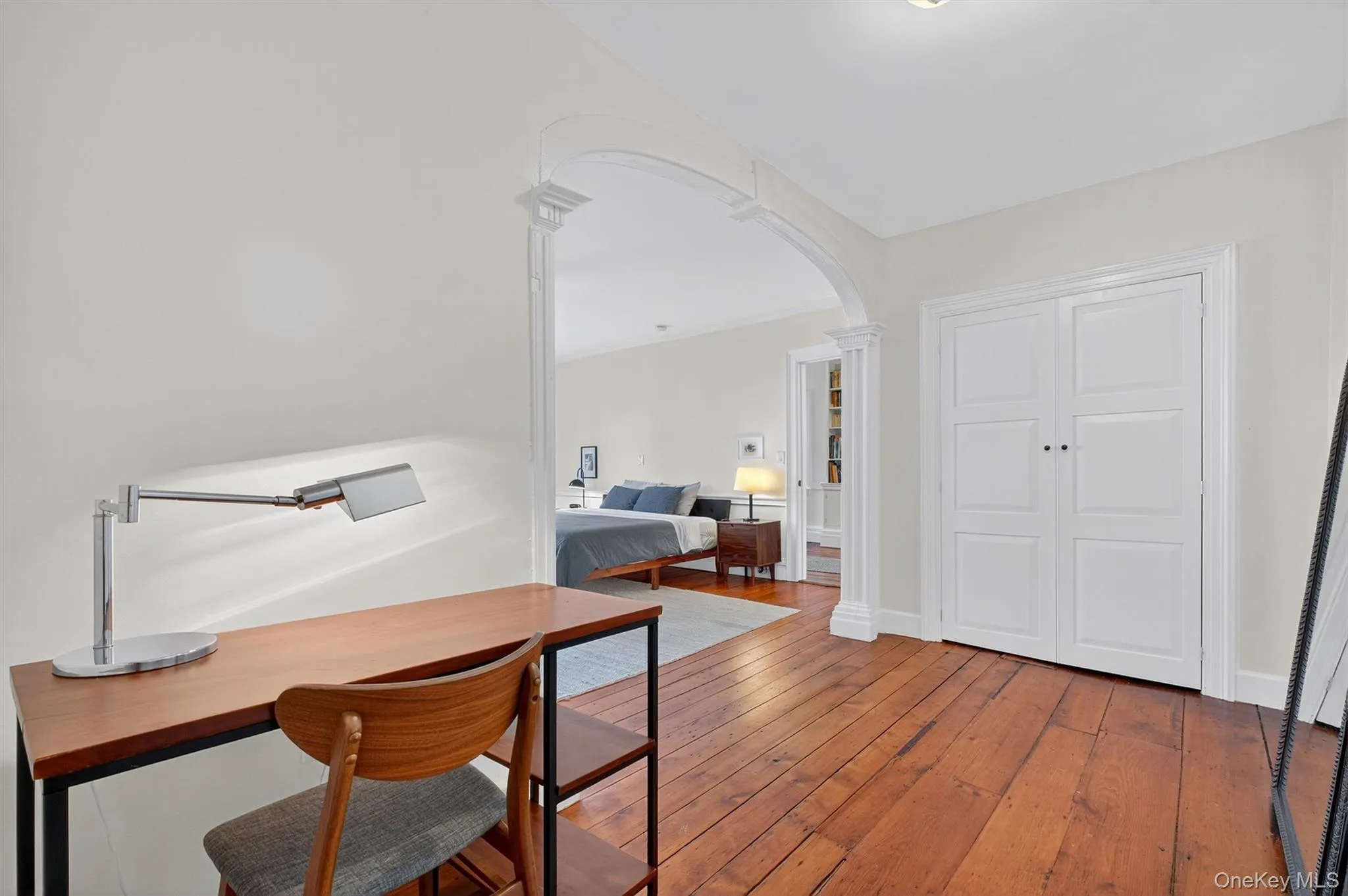 Office area with arched walkways, hardwood / wood-style flooring, and decorative columns Office area with arched walkways, hardwood / wood-style flooring, and decorative columns