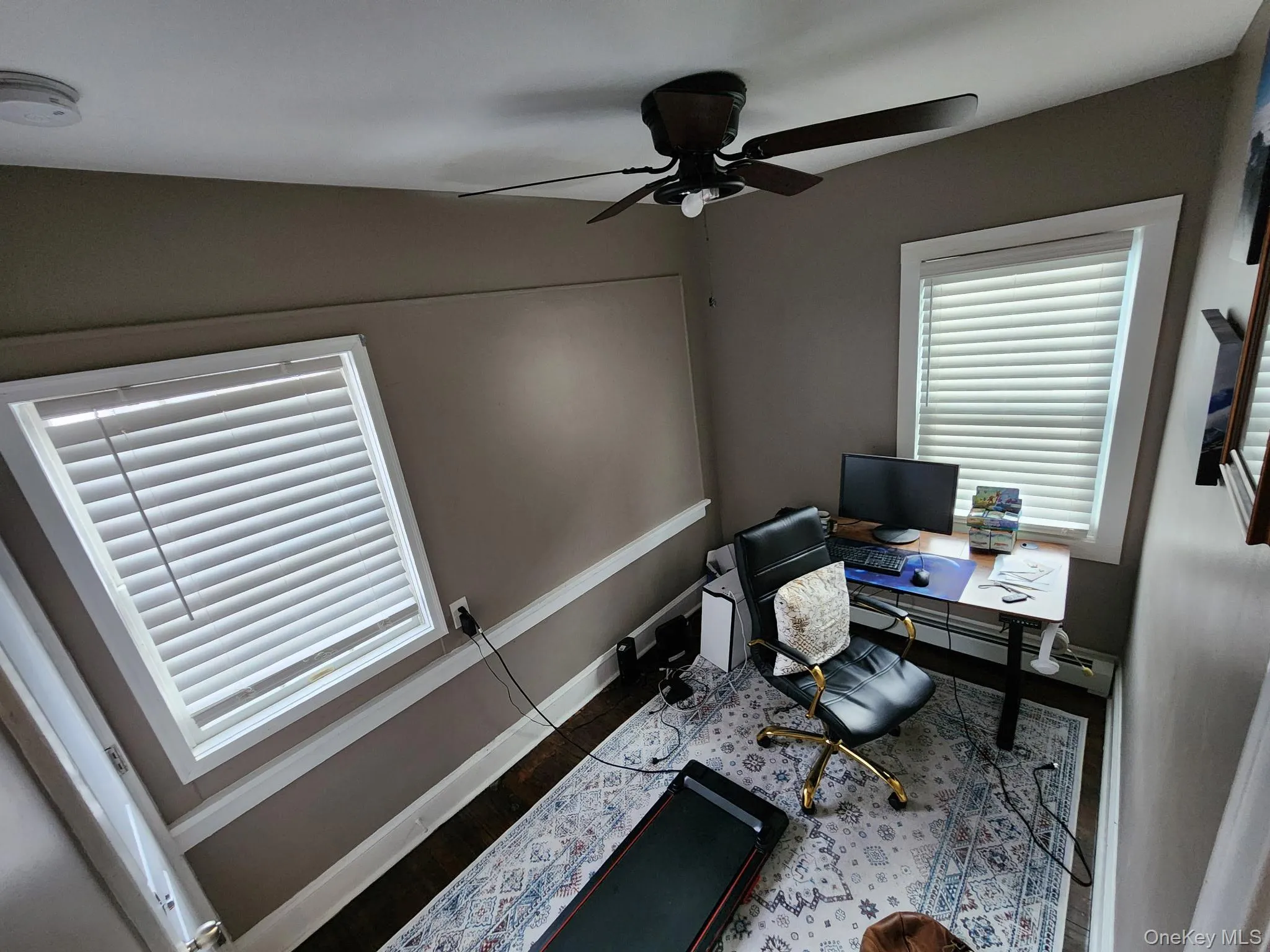 Livingroom with a ceiling fan and dark wood-type flooring Livingroom with a ceiling fan and dark wood-type flooring