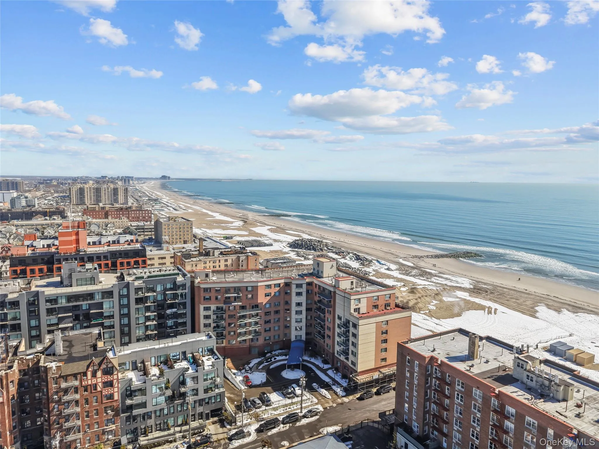 Expansive coastal landscape featuring a sandy beach, ocean, and distant city skyline Expansive coastal landscape featuring a sandy beach, ocean, and distant city skyline